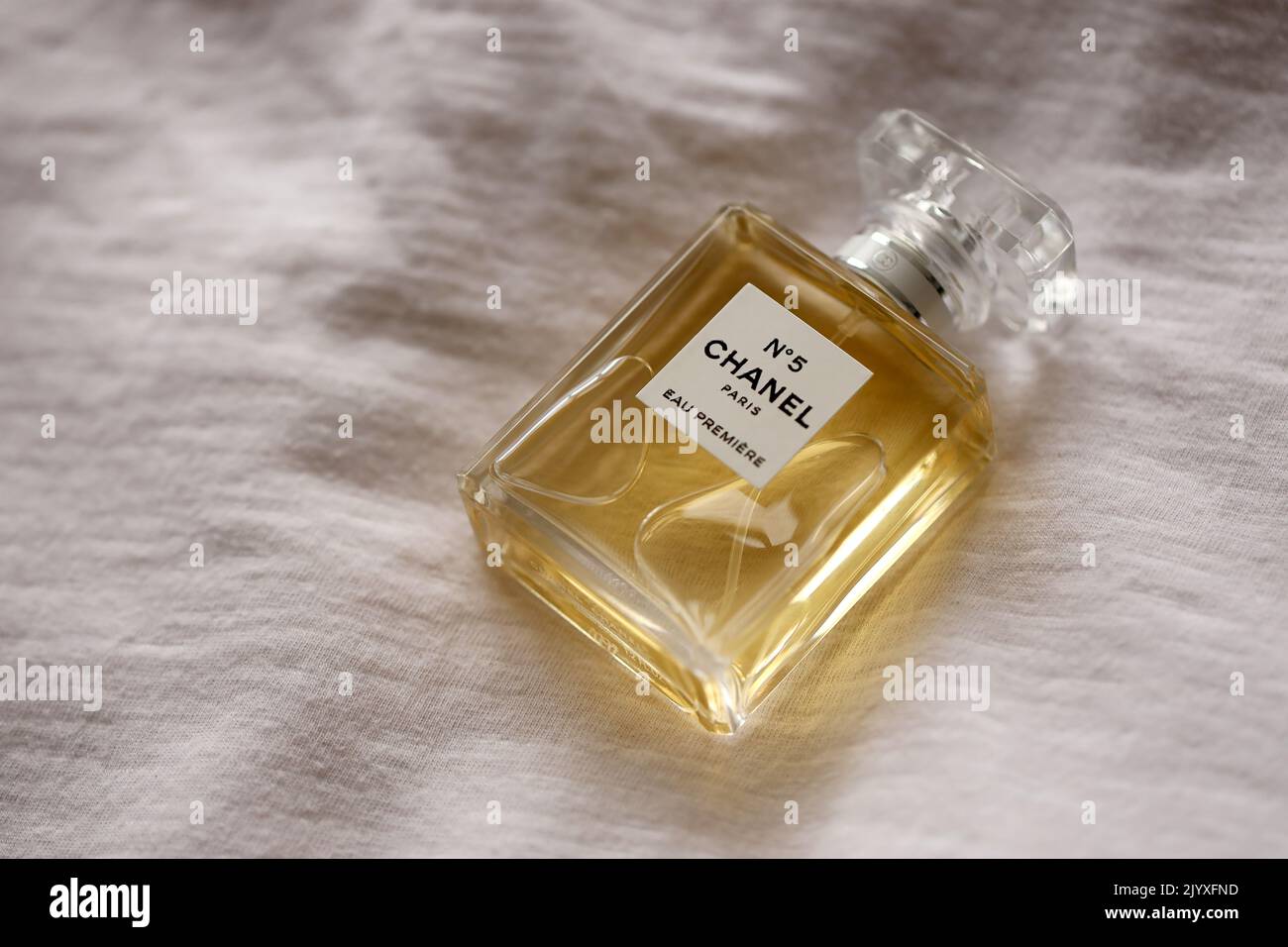 TERNOPIL, UKRAINE - SEPTEMBER 2, 2022 Chanel Number 5 Eau Premiere worldwide famous french perfume bottle on old white drapery close up Stock Photo
