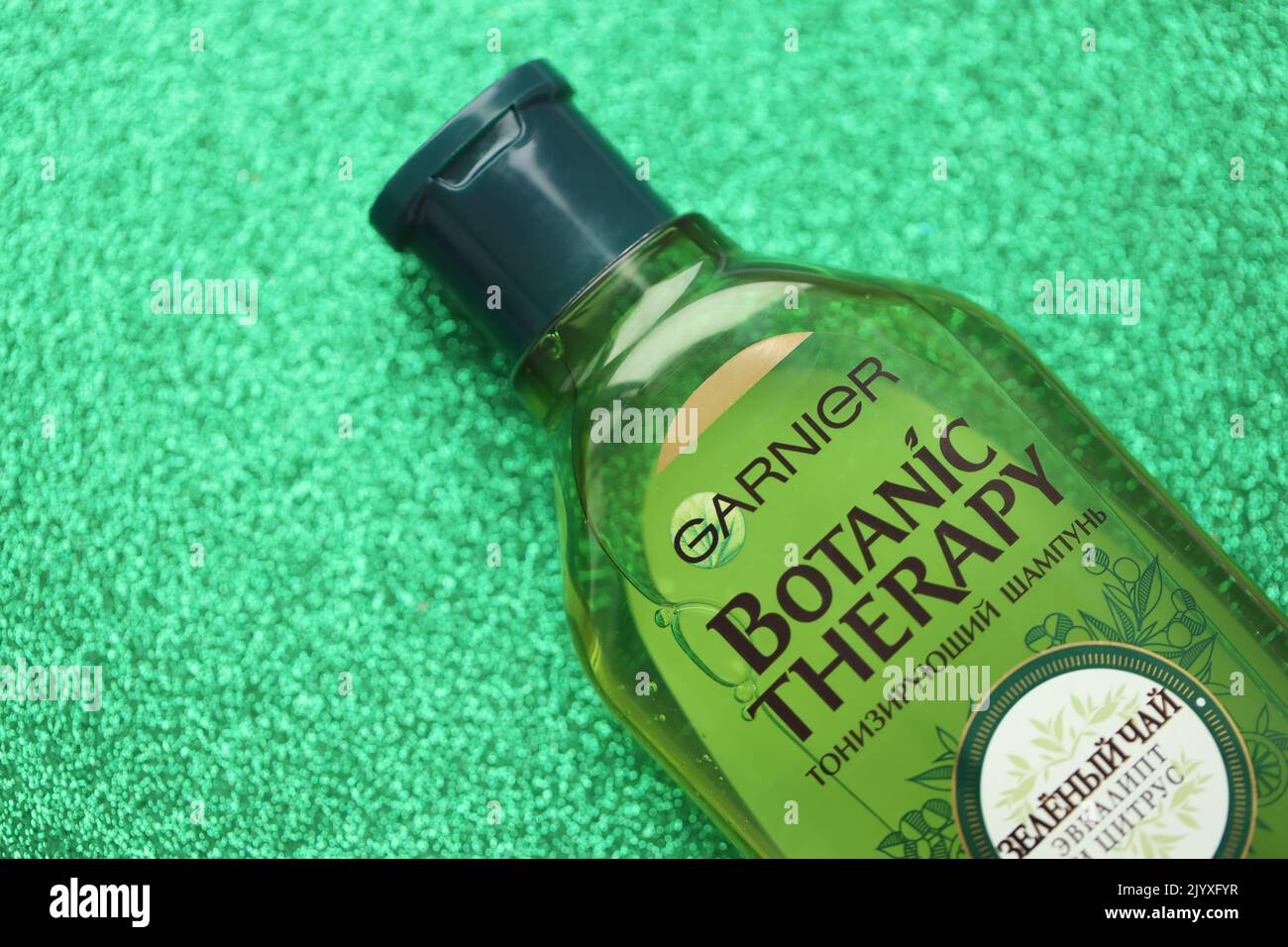 TERNOPIL, UKRAINE - SEPTEMBER 2, 2022 Bottle of Garnier Botanic Therapy Green Tea Shampoo on green glitter background surface Stock Photo