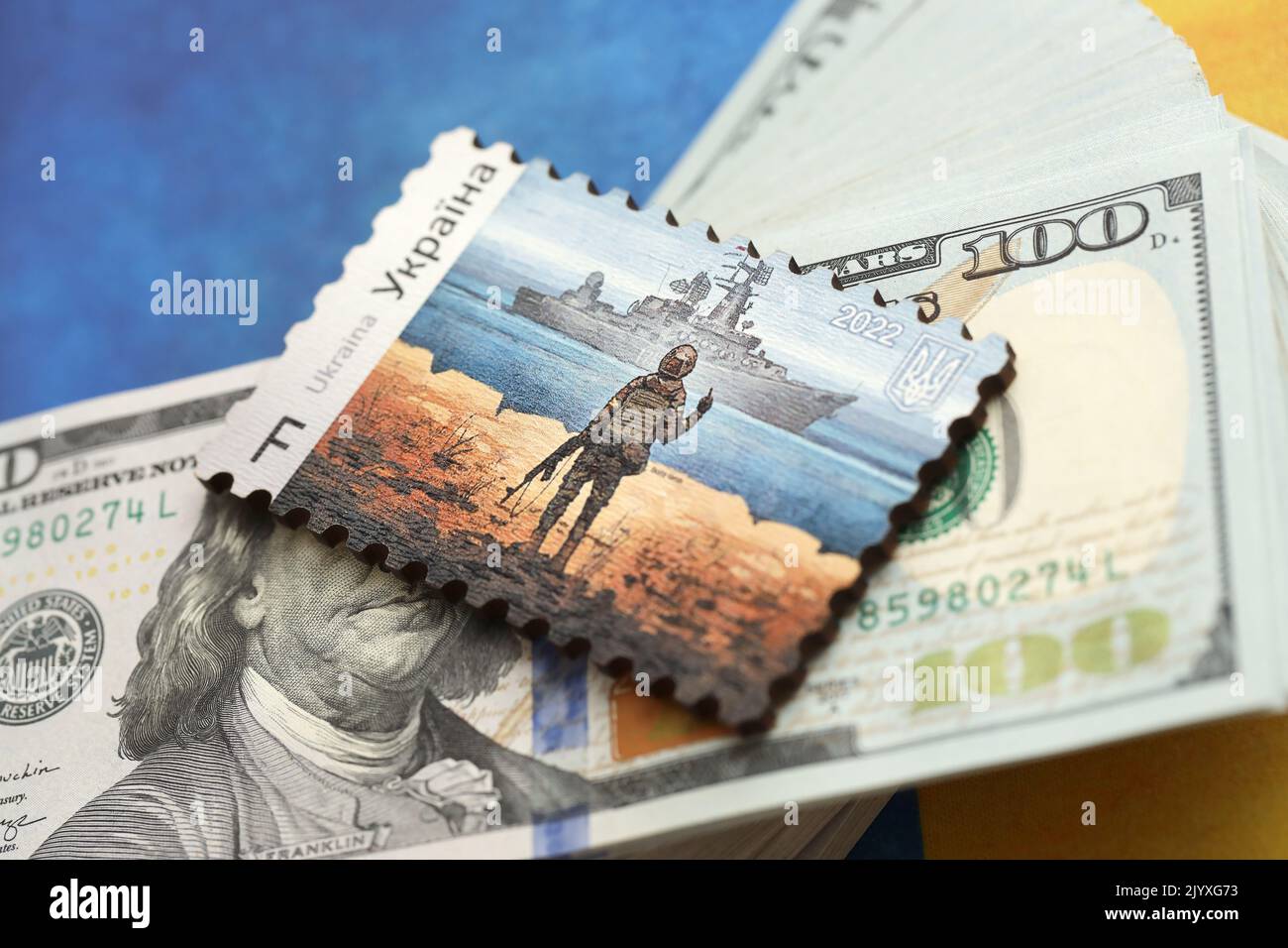 TERNOPIL, UKRAINE - SEPTEMBER 2, 2022 Famous Ukrainian postmark with russian warship and ukrainian soldier as wooden souvenir on huge amount of US dol Stock Photo