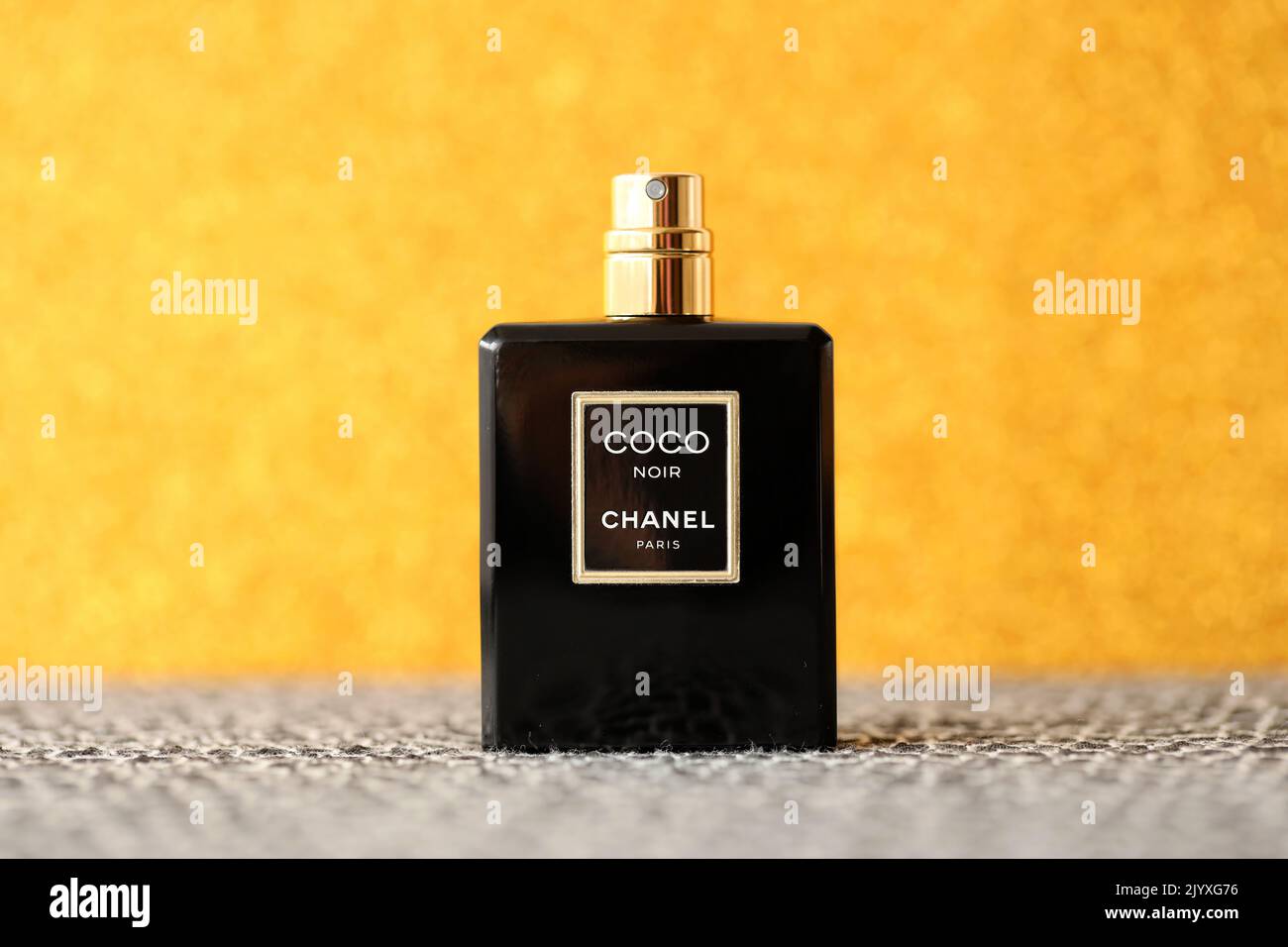 TERNOPIL, UKRAINE - SEPTEMBER 2, 2022 Coco Noir Chanel Paris worldwide famous french perfume black bottle on shiny glitter background in golden and ye Stock Photo