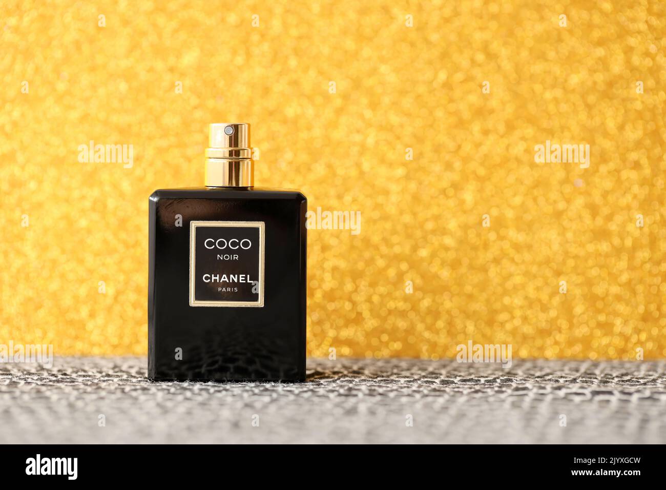 TERNOPIL, UKRAINE - SEPTEMBER 2, 2022 Coco Noir Chanel Paris worldwide famous french perfume black bottle on shiny glitter background in golden and ye Stock Photo
