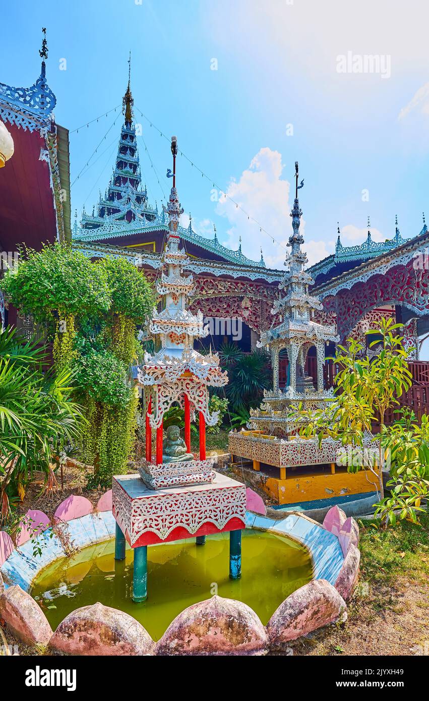 The richly decorated mini shrines with multi-tired (pyathat) roofs in garden of Wat Chong Kham Temple, Mae Hong Son, Thailand Stock Photo