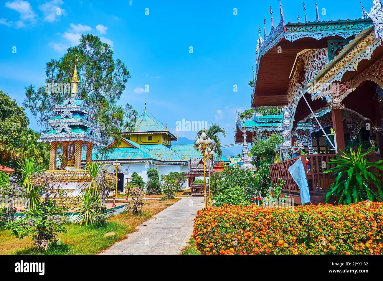 The scenic tropic garden with shrines and viharn of Wat Chong Kham Temple, Mae Hong Son, Thailand Stock Photo
