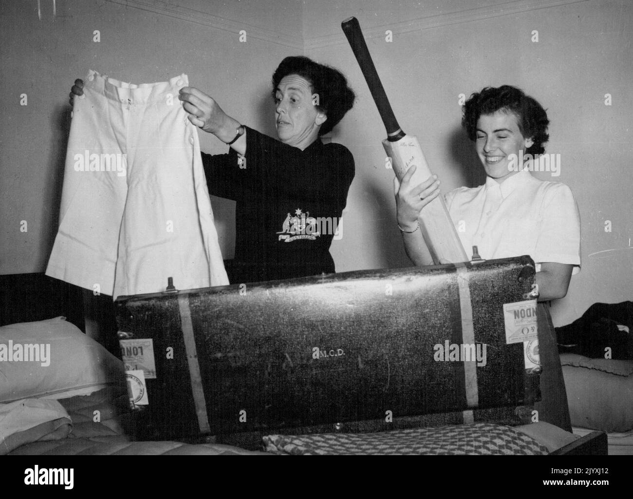 Trying their new bats in the hotel room are (left to right) Molly Dive, Captain, Mavis Jones, fast bowler, Val Batty, all rounder, and Gladys Phillips, wicket keeper, holding bat. The Australian women's cricket team arrived in England today. They are to play their first match against Kent at Sevenoaks next Saturday. After that they will play Test matches at Scarborough, Worcester and at the oval. Moan while they limber up at Lords this week. May 5, 1951. (Photo by Daily Mirror). Stock Photo