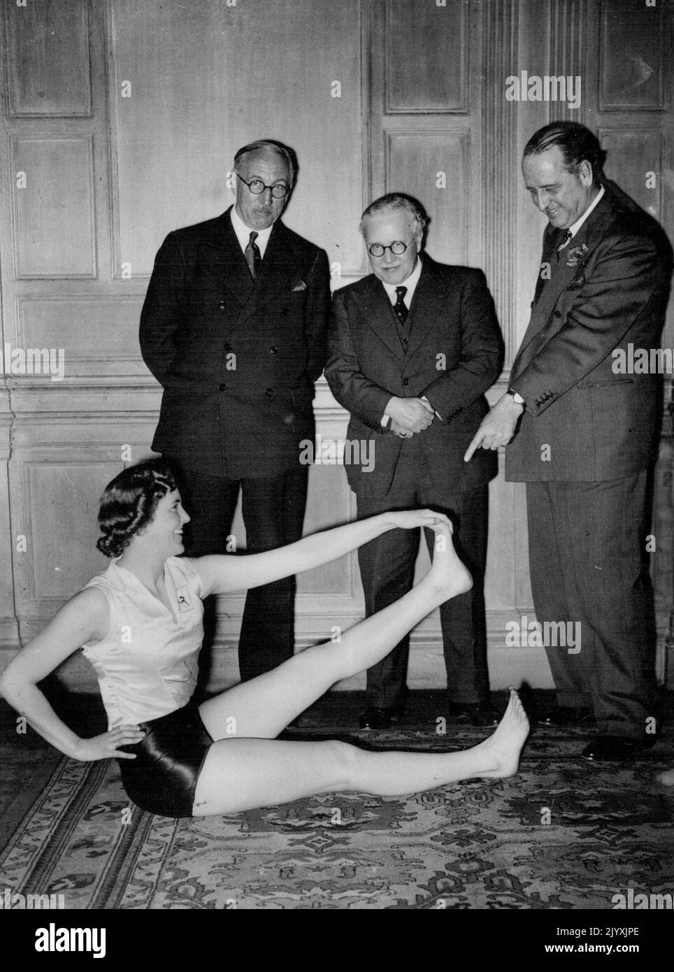 Minister Of Health Attends Health No Beauty Demonstration -- (L to R) Sir Edward Campbell, M.P., Sir Kingsley Wood and Sir Noel Curtis Bennett, K.C. watching Prunella Stack giving a demonstration. Prunella Stack and members of the Women's League of health and beauty cave a demonstration at the Hotel Metropole this evening, attended by Sir Kingsley Wood, Minister of Health. March 9, 1938. (Photo by Keystone). Stock Photo