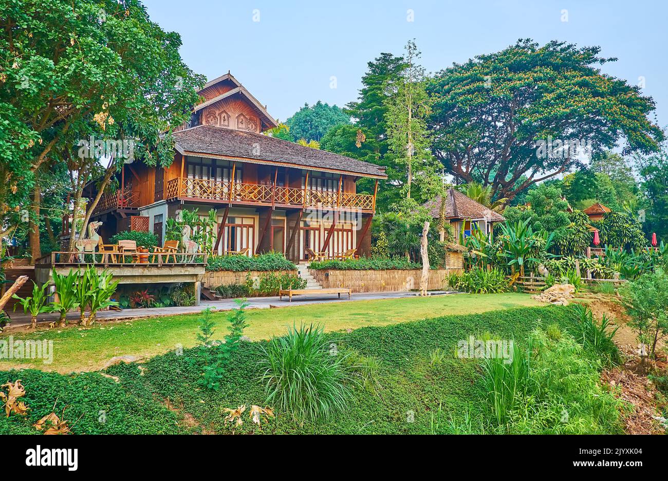 The beautiful green garden around traditional wooden Thai house on the
