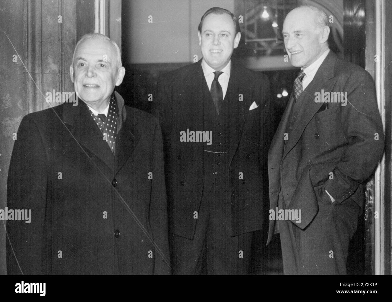 Canadian Prime Minister At No. 10, Downing Street - The Canadian Prime Minister (left) seen upon arrival at No. 10, Downing Street for lunch on Saturday, in the company of Viscount Swinton, Secretary for Commonwealth Relations (right). They are being greeted by Captain Christopher Soames, Sir Winston Churchill's son-in-law. Mr. St. Laurent, the Canadian Prime Minister, who is on a world tour, arrived at London Airport on Friday night (Feb. 5th), accompanied by his son Jean Paul, and his daughter Mrs. Hugh O'Donnell. On Saturday, Feb. 6th., Mr. St. Laurent and his family were entertained to lun Stock Photo