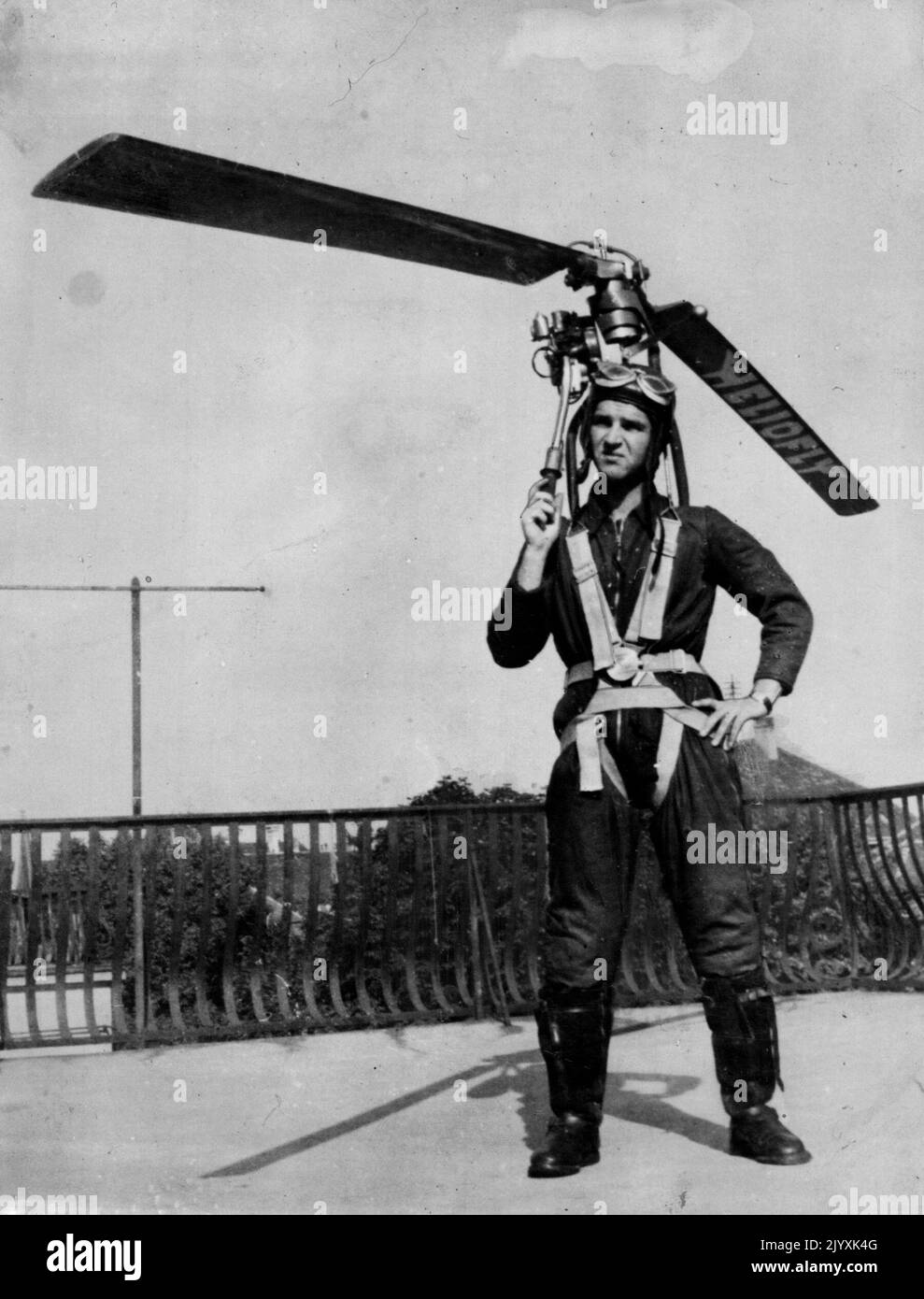 Everybody Can Wear His Own Autogyro, Take Off In Street -- Paul Baumgartl wearing the 'Heliofly'. The 'Heliofly', a device which, strapped to the body, enables the wearer to take off in the street, climb to an altitude of 3,000 feet and fly Baumgartl, a 28-year-old Viennese technician, after three years' experiment and trial. The apparatus consists of an air screw resembling an autogyro's, and a motor; total weight does not exceed 30 pounds. Baugartl says he is going to start mass production of the 'Heliofly' as soon as the Allied occupation authorities permit powered aviation in Australia. Oc Stock Photo