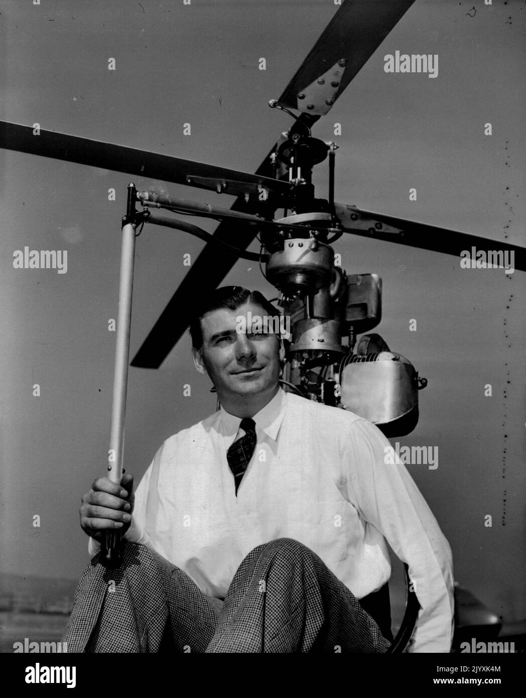 Air Motorcycle -- Inventor Horace Pentecost sits in the 'cabin' of his 'Hoppicopter', a one-man helicopter, with his right hand on the 'stick'. This is pilot model, which according to the inventor has not yet been in free flight. July 29, 1949. (Photo by Wide World Photos). Stock Photo