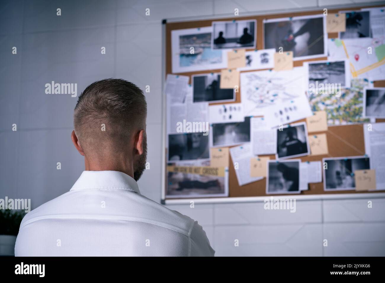 Policeman Or Private Detective Searching Crime Investigation Board Stock Photo