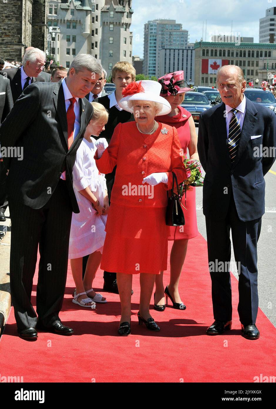 File photo dated 1/7/2010 of Queen Elizabeth II, in the red and white colours of the Canadian flag, with Stephen Harper the Prime Minister of Canada (left), and the Duke of Edinburgh, after arriving to attend the Canada Day celebrations, in Ottawa. Elizabeth II was famed for her love of block colours and matching hats and her fashion became a legendary part of her role as monarch. The Queen was once described as 'power dressing in extremis' for using vibrant shades to make herself stand out from the crowd while her hats allowed her to be easily spotted but were small enough so her face was vis Stock Photo