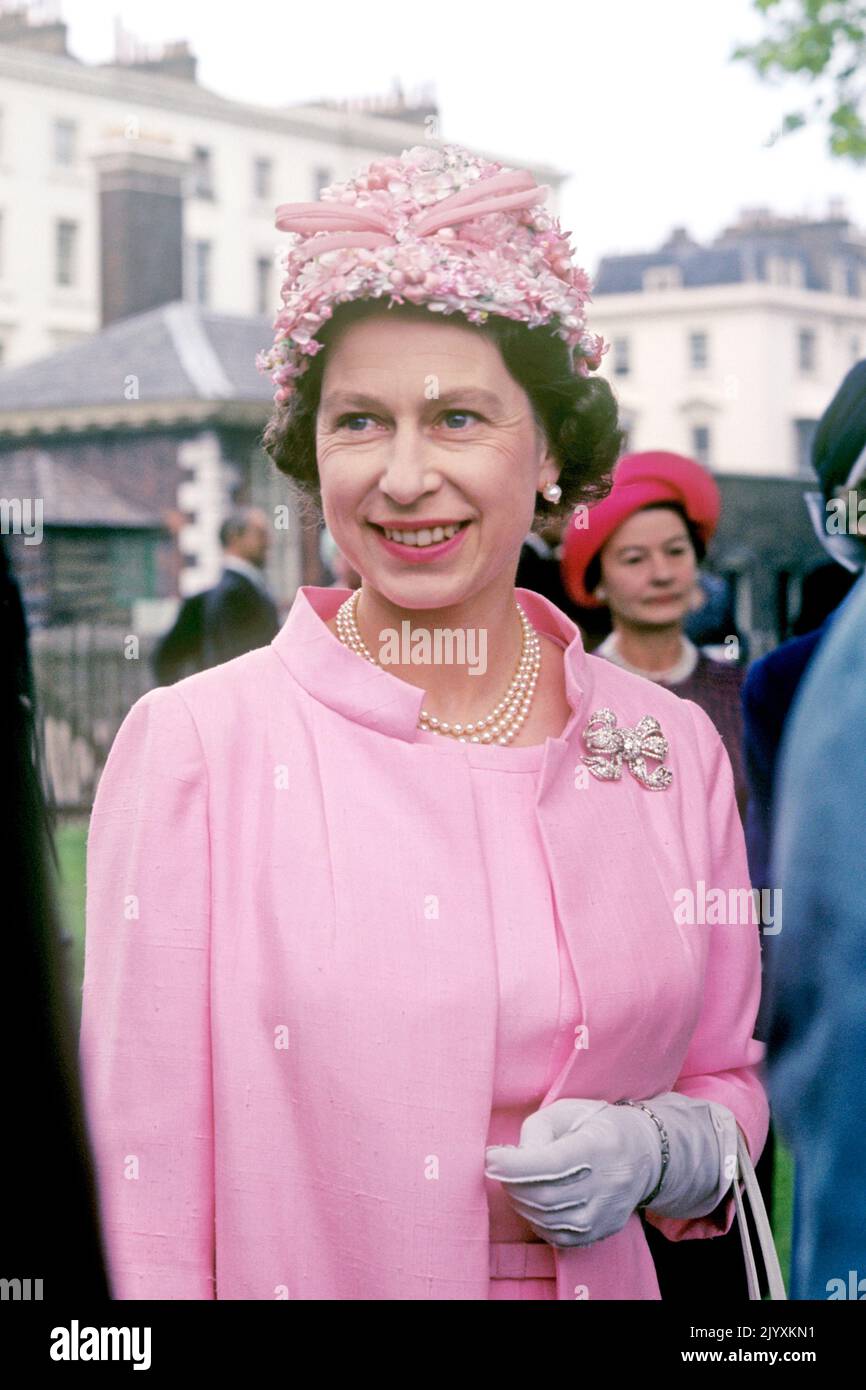 File photo dated 1/6/1967 of Queen Elizabeth II at a garden party in the grounds of the Royal Hospital, Chelsea, London, in connection with the 50th anniversary of the Women's Services. Elizabeth II was famed for her love of block colours and matching hats and her fashion became a legendary part of her role as monarch. The Queen was once described as 'power dressing in extremis' for using vibrant shades to make herself stand out from the crowd while her hats allowed her to be easily spotted but were small enough so her face was visible. Issue date: Thursday September 8, 2022. Stock Photo