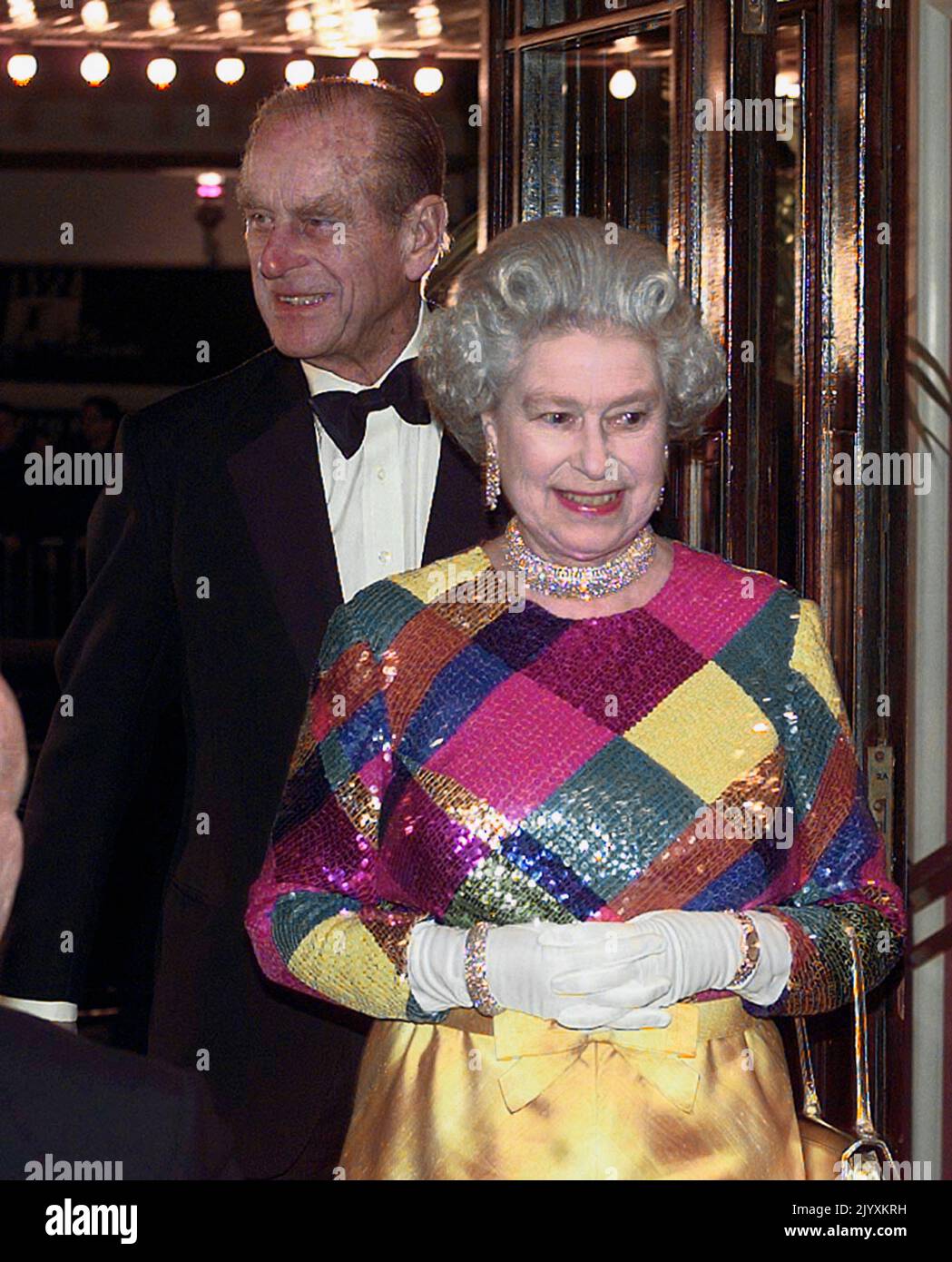 File photo dated 29/11/1999 of Queen Elizabeth II wearing a multi-coloured sequinned evening gown as she and the Duke of Edinburgh arrived at Birmingham Hippodrome for the 1999 Royal Variety Performance. Elizabeth II was famed for her love of block colours and matching hats and her fashion became a legendary part of her role as monarch. The Queen was once described as 'power dressing in extremis' for using vibrant shades to make herself stand out from the crowd while her hats allowed her to be easily spotted but were small enough so her face was visible. Issue date: Thursday September 8, 2022. Stock Photo