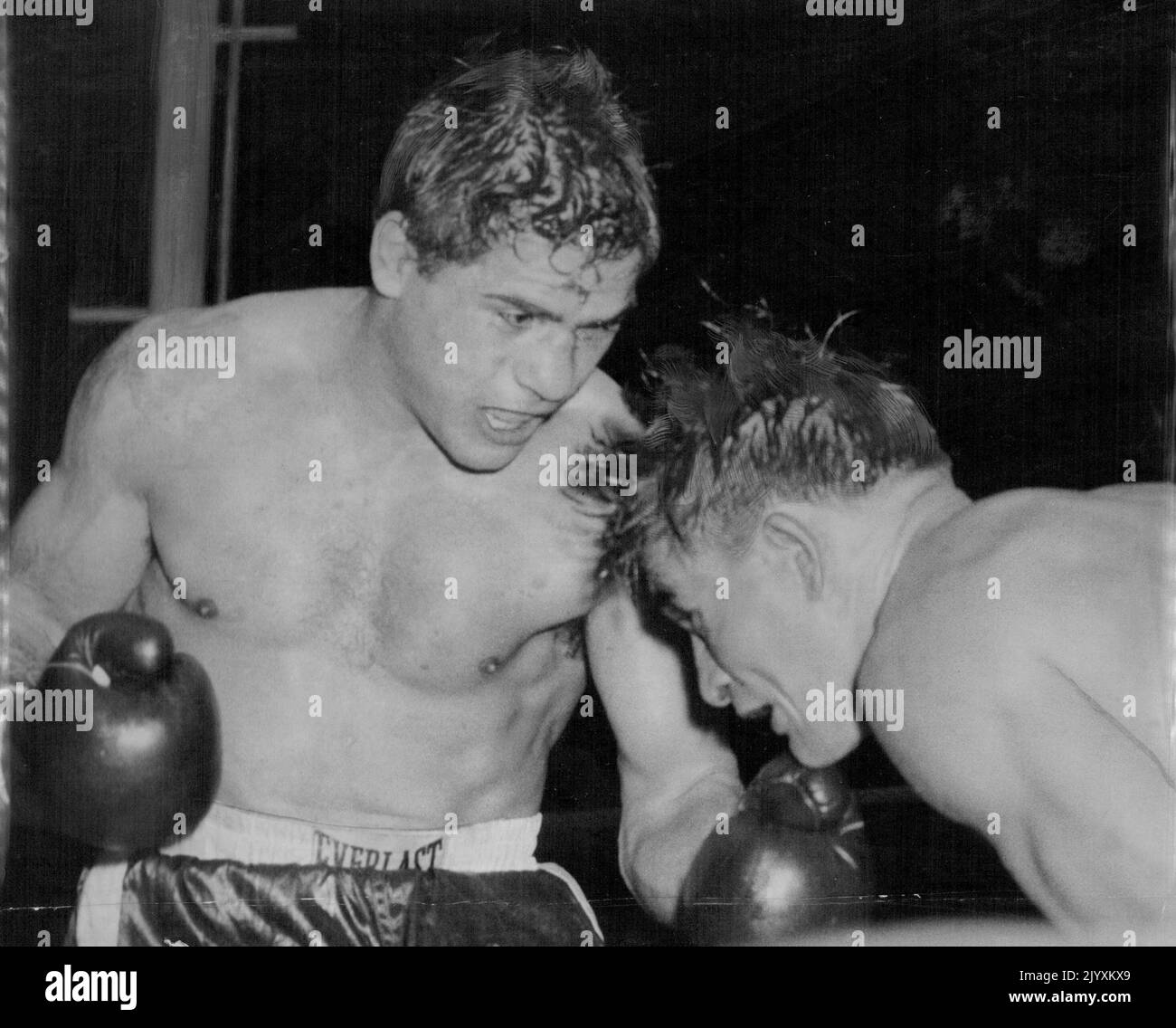 Italo Scortichini has used his left and is about to come through with his right as the crouching George Barnes moves in during last night's fight at the White City. April 15, 1955. Stock Photo