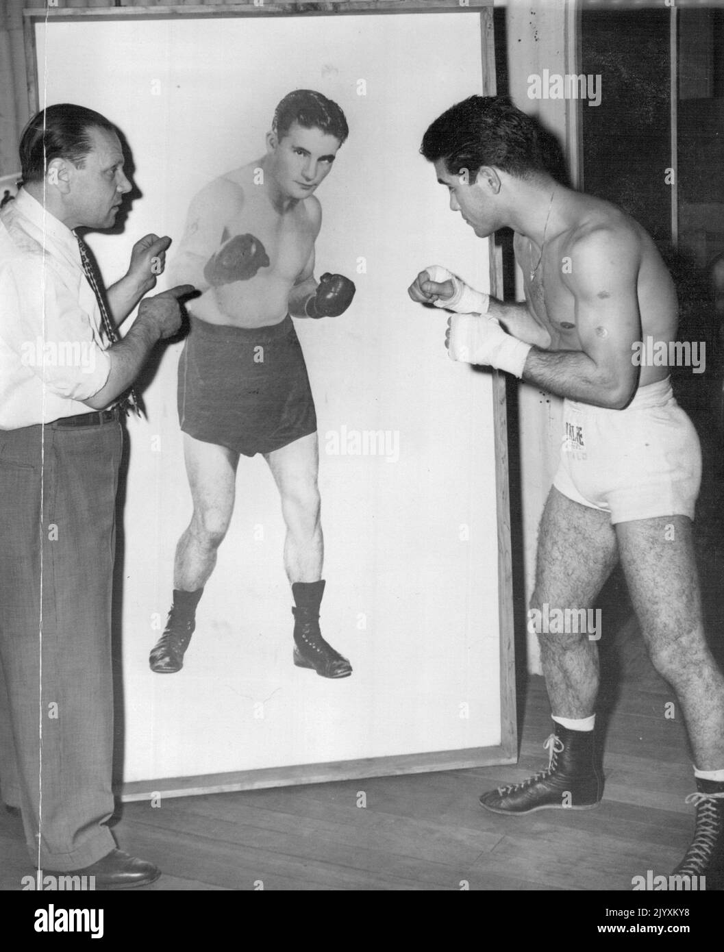 Italo Scortichini shows up to victims of George Barnes whom he will fight at White City on Thursday night painting to Barnes is ***** manager, Carmine Tarantino. April 19, 1955. Stock Photo