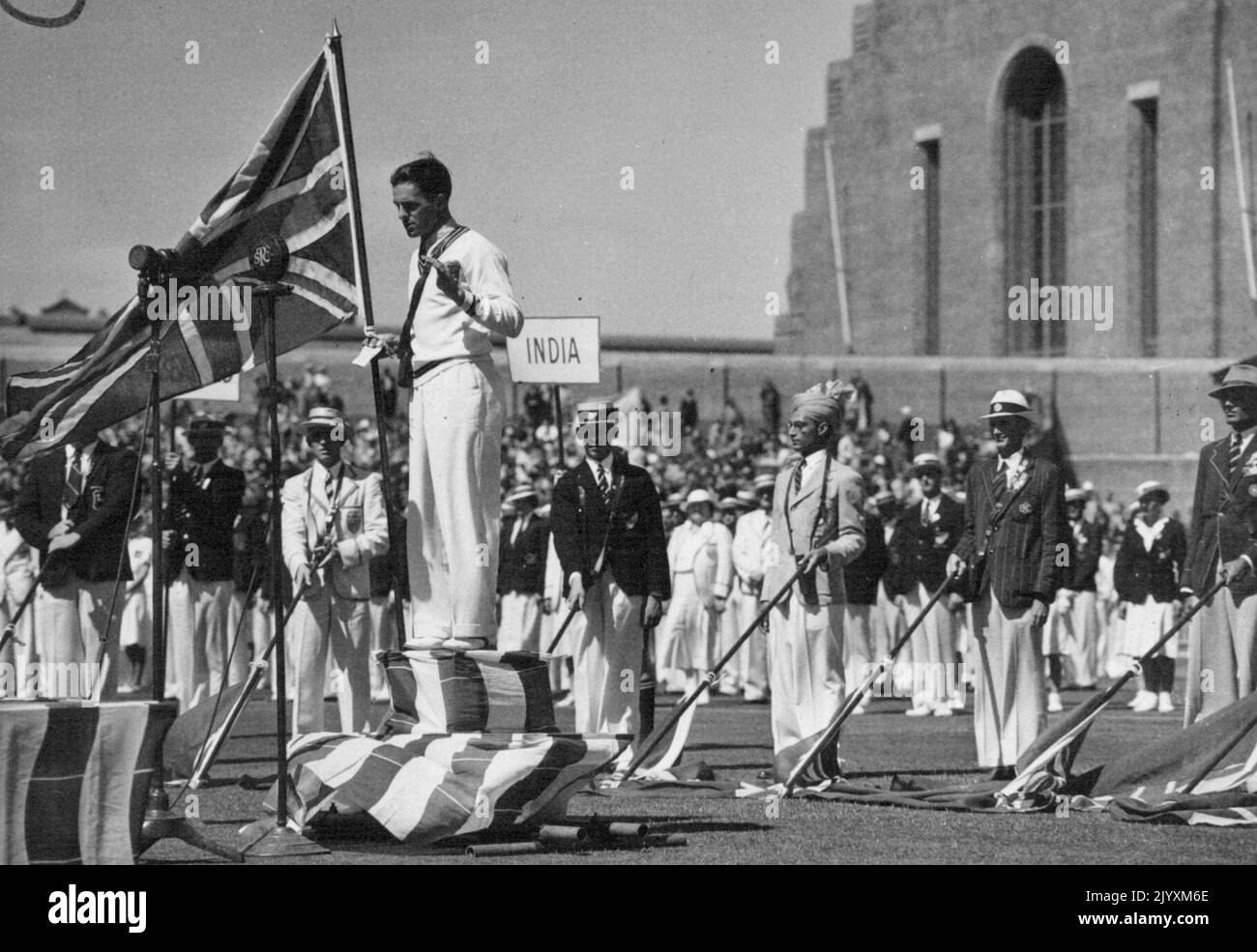 Empire Games at Sydney Cricket Ground. E L. Gray, Australian cyclist, takes the oath of amateurism on behalf of athletes competing in the Empire Games. Directly behind him, in turban, is Janki Dass, the sole Indian representative. May 09, 1938. Stock Photo