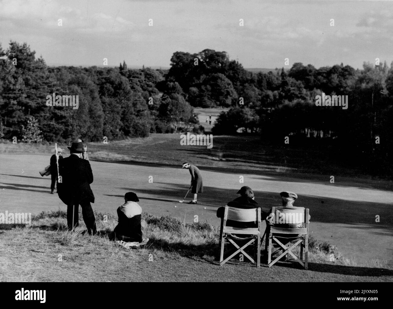 First Day Of The Worplesdon Foursomes - The Open mixed scratch foursomes golf tournament opened at Worplesdon, Surrey to-day. This picture shows A Group of spectators as they watch play in one of the greens, against a pleasant Surrey background. November 8, 1954. (Photo by Daily Mail Contract Picture). Stock Photo