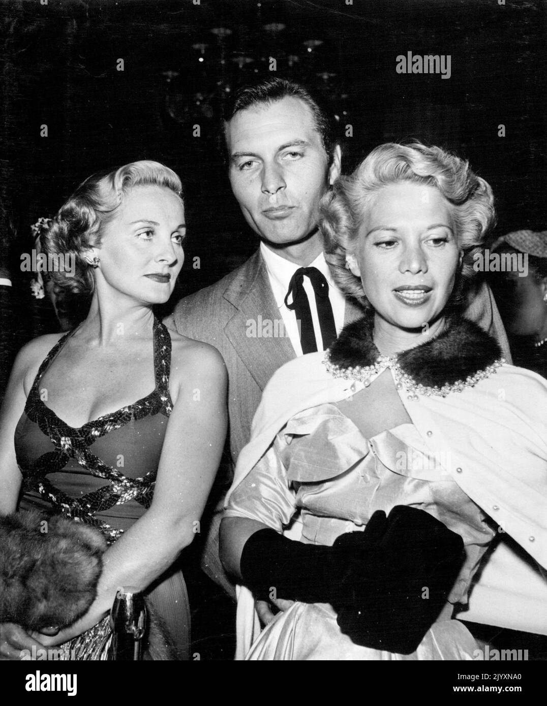 Dinah Shore and husband George Montgomery with one-time star Constance Moore. Dinah caused quite a stir with her cardigan-type jacket with its mink and pearl collar. December 2, 1952. Stock Photo