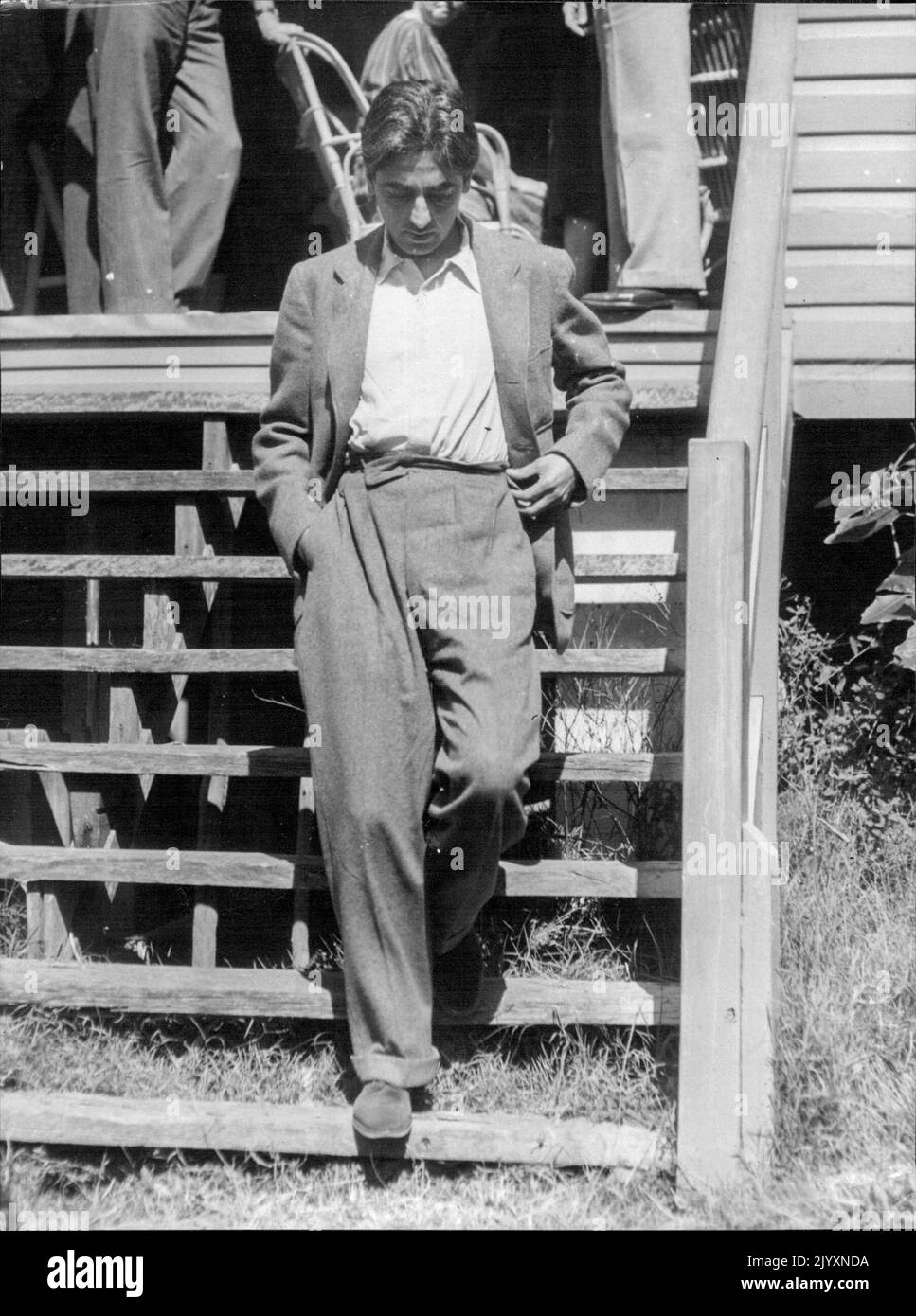 Krishnamurti - Pensively, Krishnamurti walks down steps after hour's session writer gathering a Workers' Ed. Ass. members at Newport (N.S.W.) Krishnamurti travelled from Sydney by taxi Wendsday for a week to conduct personal discussions on life members holidaying at Newport at conclusion of wing parley, Krishnamurti immediately left building, Strolled alone in roadway until taxi party ready to leave for city. March 08, 1947. Stock Photo