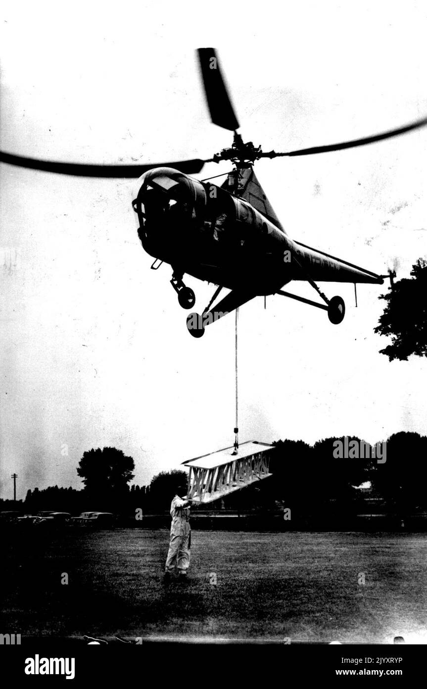Aerial Crane. The 'Westland Sikorsky,' the first commercial-type helicopter available in Europe demonstrates how it can drop its own hoisting gear and while hovering, pick up a steel girder, offering an easy method of bridging a river from the air. The aircraft accommodates a pilot and three passengers in a luxury cabin, air-conditioned and warmed. June 1, 1947. (Photo by Sport & General Press Agency, Limited). Stock Photo