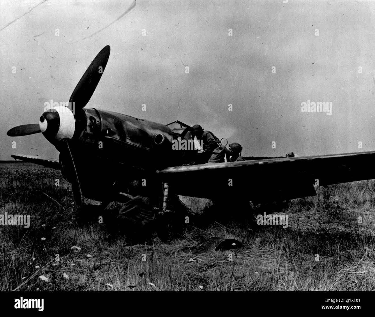 Fighter Plans Abandoned By Retreating Nazis -- American soldiers examine a German FW-190 fighter plane left behind by Germans fleeing from the Nogent-le-Roi sector in Franco. The American advance in this area was so overwhelming and swift that the Nazis had no time to take the plane with them. This picture has just been released by the consors. January 1, 1945. (Photo by U.S. Signal Corps Photo). Stock Photo