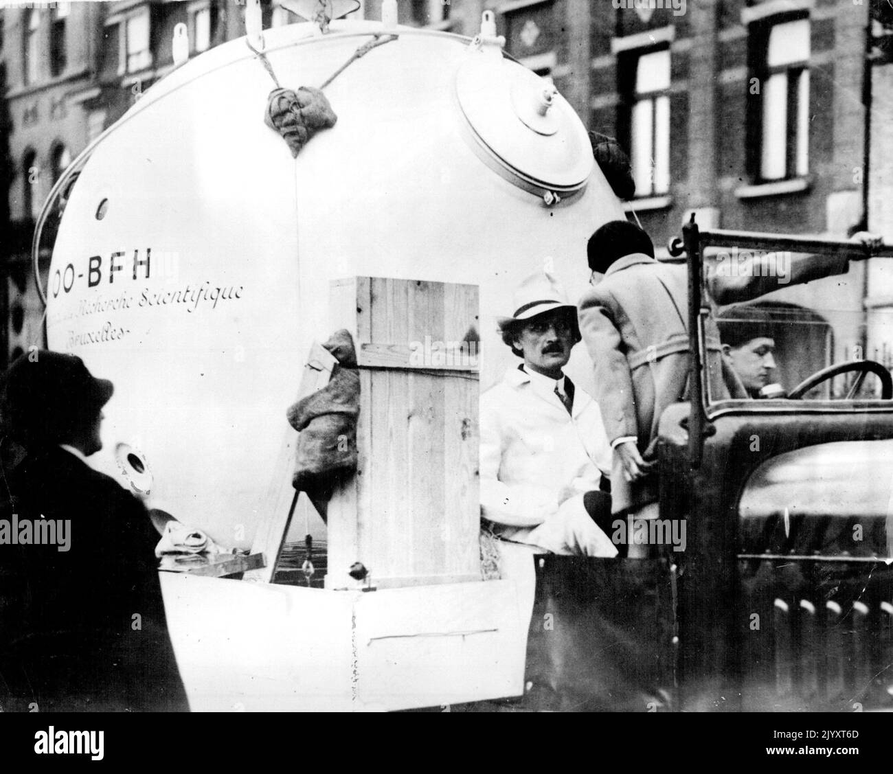 Prof. Piccard Leaves For Zurich Flight Into Stratosphere -- Professor Piccard about to leave Brussels on lorry with his new aluminium sphere in which he will make the flight. Professor Piccard, accompanied by his helper Max Cosyns and M. Kipper, left Brussels yesterday August 1 for Zurich where he will ascend into the stratosphere as soon as weather conditions permit. The Professor is not aiming to beat his previous record but to study the cosmic rays. He will take with him a short-wave transmitting wireless set. September 26, 1932. (Photo by The Associated Press of Great Britain Ltd.). Stock Photo