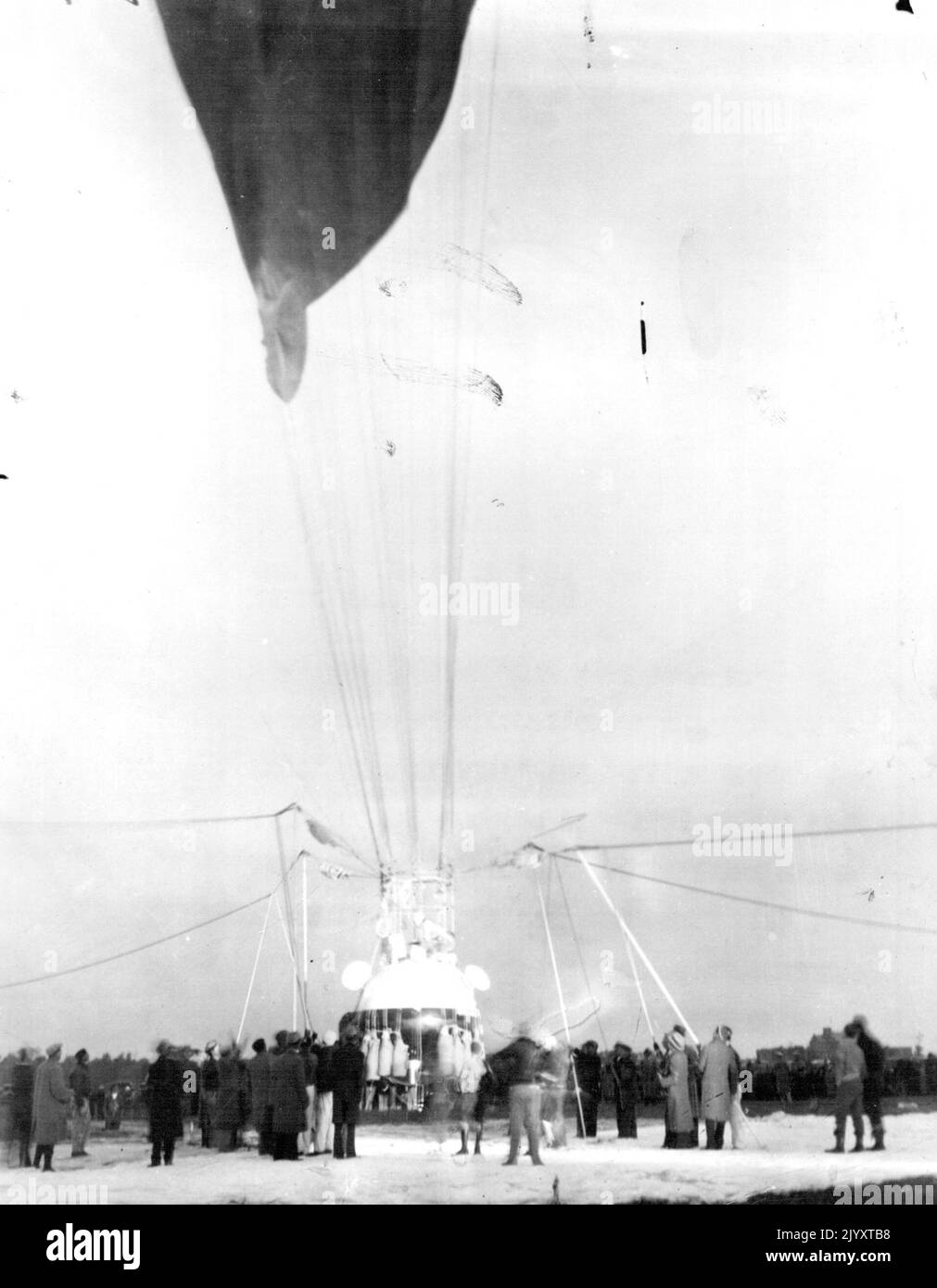 Piccards Off For Stratosphere -- Close to 250 men were in the ground crew that prepared the stratosphere balloon of Prof. and Mrs. Jean Piccard at Detroit, Mich., for their long flight into the upper air. The picture shows the crew about to release the balloon early on the morning of Oct 23, at the ford airport, near Detroit. The balloon soared eastward and landed near Cadiz, Ohio. Neither the Piccards nor their instruments were injured. October 23, 1934. (Photo by Associated Press Photo). Stock Photo