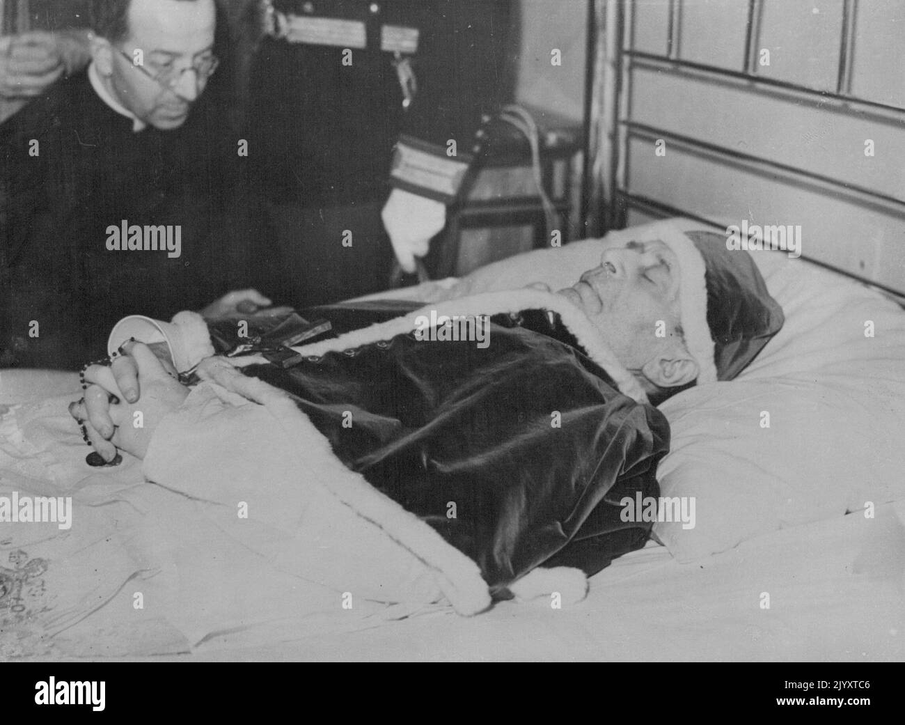 O.P.S.Dressed in a white habit, a small red Mantee over his shoulders, the camera, A small cap attached to the Mantle, covering his head....The body of Pope Puis XI, lies on his bead in the Vatican. February 11, 1939. (Photo by Keystone) Stock Photo