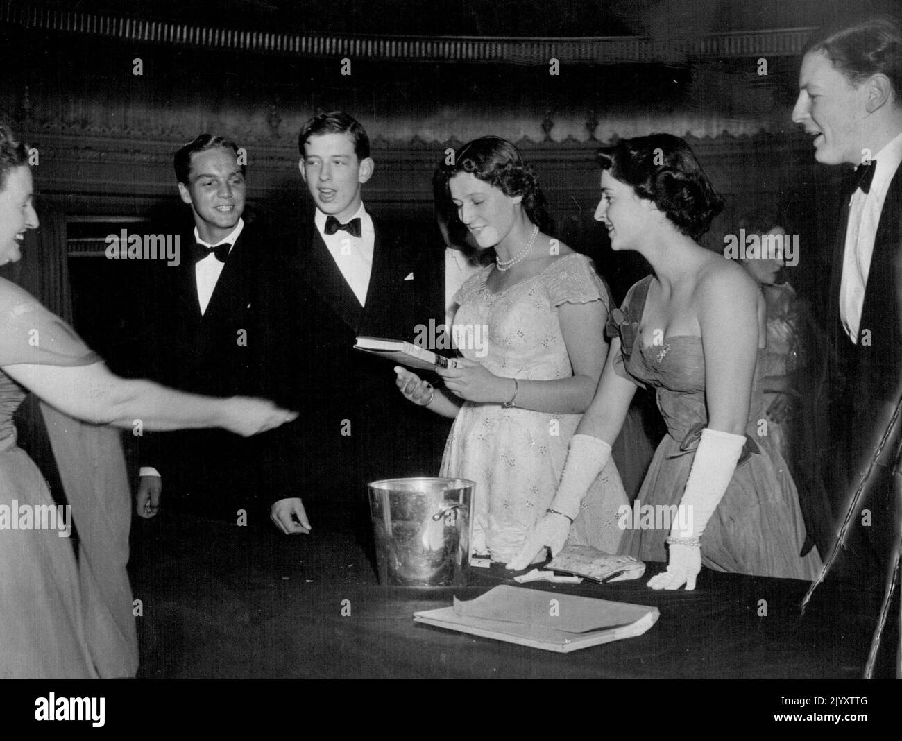 The Eton Beagles ball at the Dorchester Hotel on July 10th, 1953 Mrs. David Copland hands the prizes of a book to Princess Alexandra which she won at the Tombola from l to r are Mr. Jeremy James, The Duke of Kent Princess Alexander, Princess Elizabeth of Yugoslavia and the Hon, Angus Ogilvy. August 24, 1953. Stock Photo