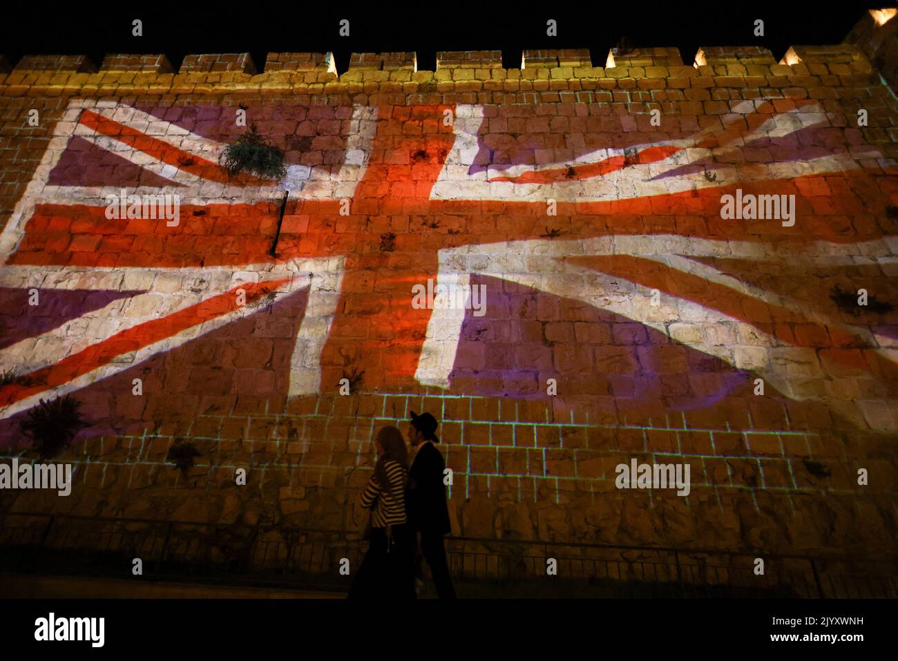 A fragment of the walls of Jerusalem's Old City is illuminated with the Union Jack flag following the death of Queen Elizabeth, Britain's longest-reigning monarch, in Jerusalem September 8, 2022. REUTERS/Ronen zvulun Stock Photo