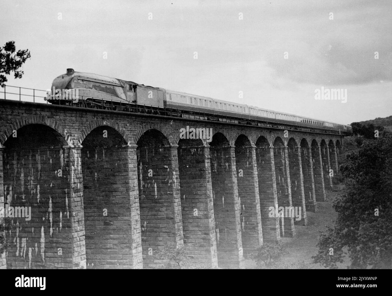 L. N. E. R. Coronation Train's Trial Run - The London & North Eastern Railways a new blue and white, streamlined "Coronation" express roaring over the Eighteen Arches Viaduct across the River Aln, Northumberland, yesterday on her first trial run from London to Edinburgh, These new "Coronation" expresses commence service on Monday and will make the Journey between London and Edinburgh in six hours. July 02, 1937. (Photo by Topical Press). Stock Photo