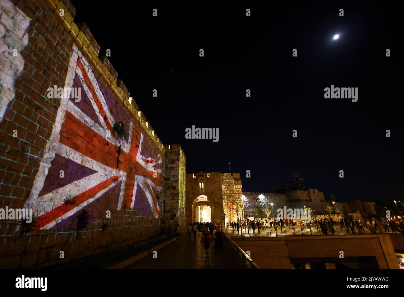 A fragment of the walls of Jerusalem's Old City is illuminated with the Union Jack flag following the death of Queen Elizabeth, Britain's longest-reigning monarch, in Jerusalem September 8, 2022. REUTERS/Ronen Zvulun Stock Photo