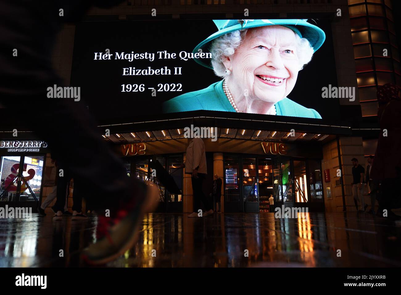 A tribute to Queen Elizabeth II is displayed on a big screen in ...