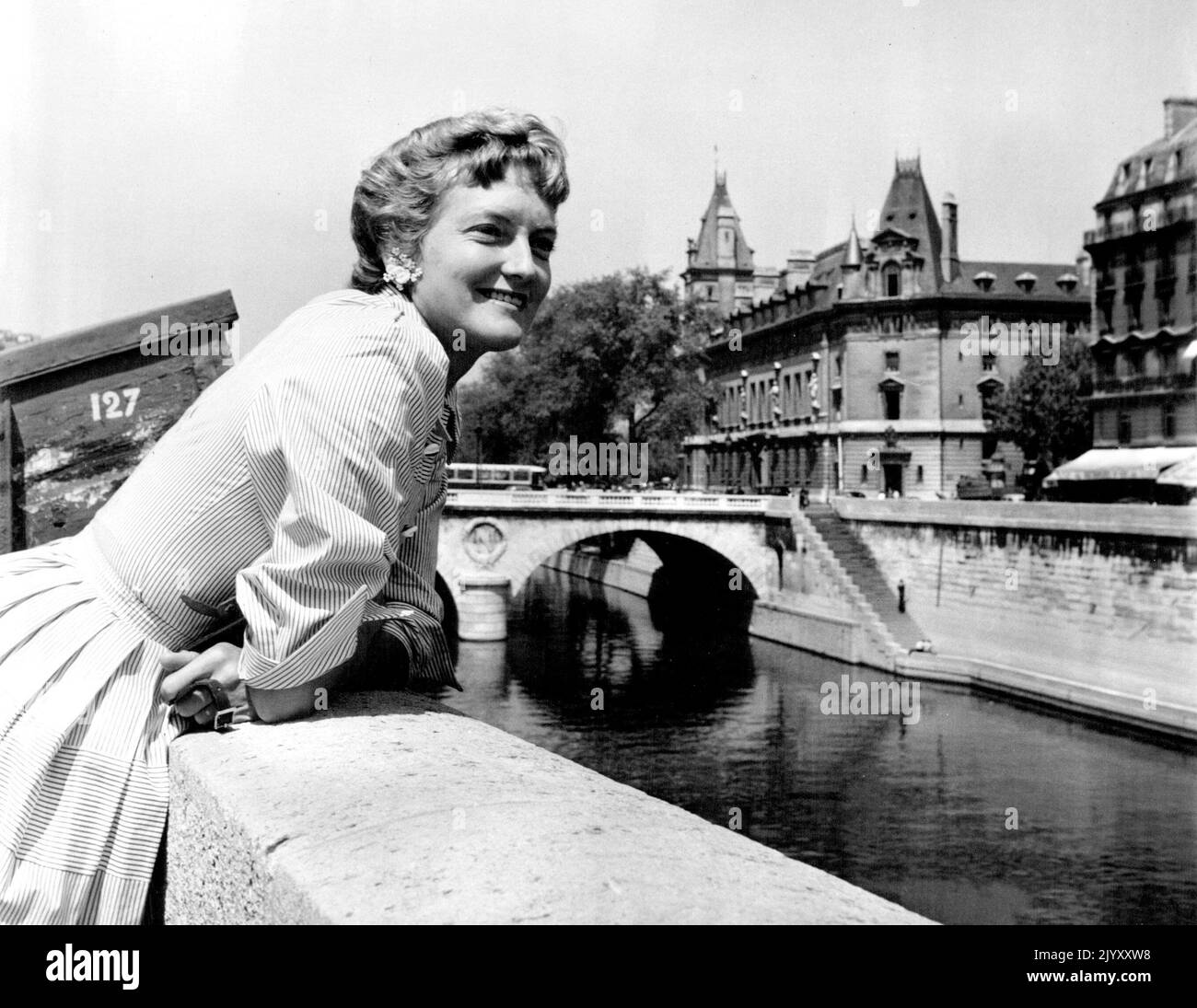 Oakes - Australia's champion, Beryl Penrose, who reached the quarterfinals of the French titles, loved the Seine quais, where one can lean and watch the river, admire the bridges and the old buildings and lift one's eyes to the Gothic towers of Notre Dame. June 21, 1955. (Photo by Michel Brodsky). Stock Photo