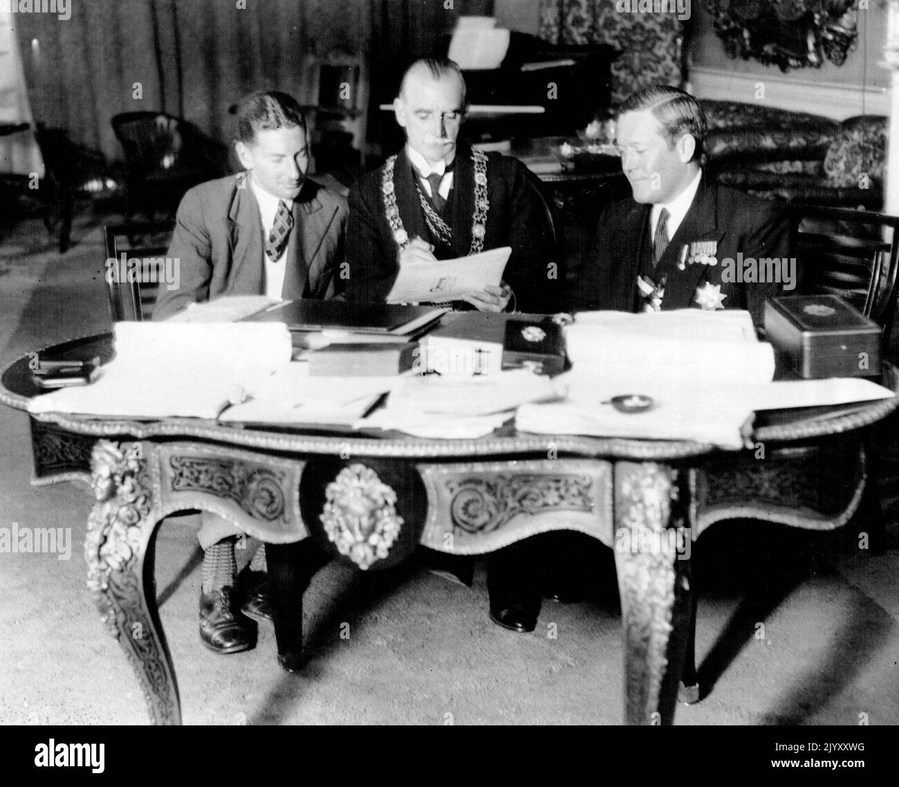 Australian Airman in Dublin - (L to R) Mr. Warren Ponny, of Australia, said to have been once the youngest pilot in the world, and who intends to pilot the plane named the 'Vultee' V.I.A. in the London to Melbourne air race next month, showing the Lord Mayor of Dublin, his plane. Captain Pond, the Atlantic flyer, who is a visit to Dublin, who will act as hisco-pilot, and navigator, is also in picture. September 27, 1934. (Photo by Keystone). Stock Photo