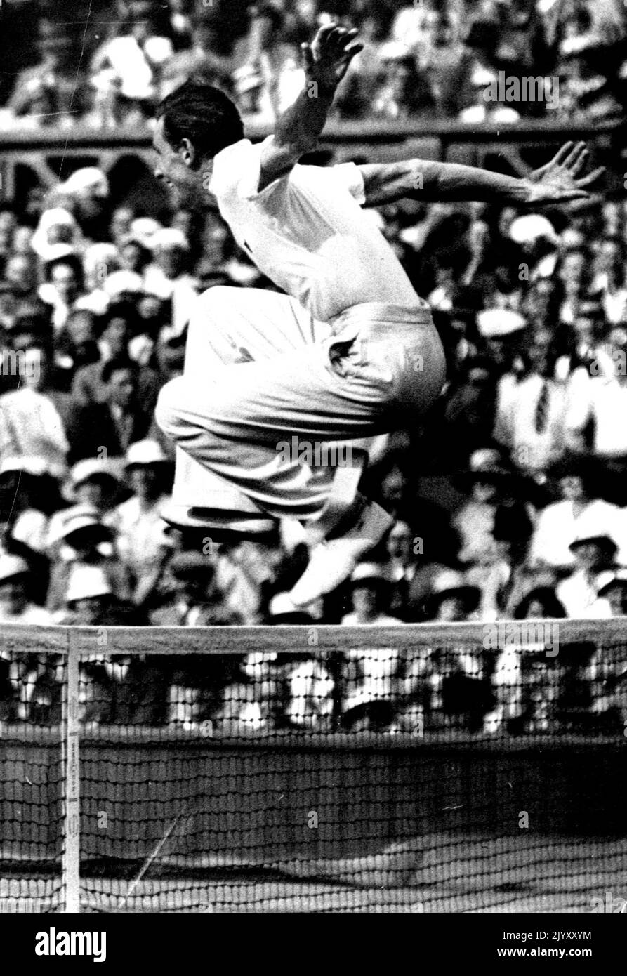 Perry's Victorious Leap! F.J. Perry delightedly jumps the net to shake hands with his opponent S.B. Wood after their match. Gt. Britain and Australian to meet in the finals at Wimbledon. Fred Perry by defeating S.B. Wood (U.S.A.) July 4th., in the semi-finals of the men's singles championships at the Wimbledon tennis, now meets Jack Crawford (Australia) in the finals. August 06, 1934. Stock Photo