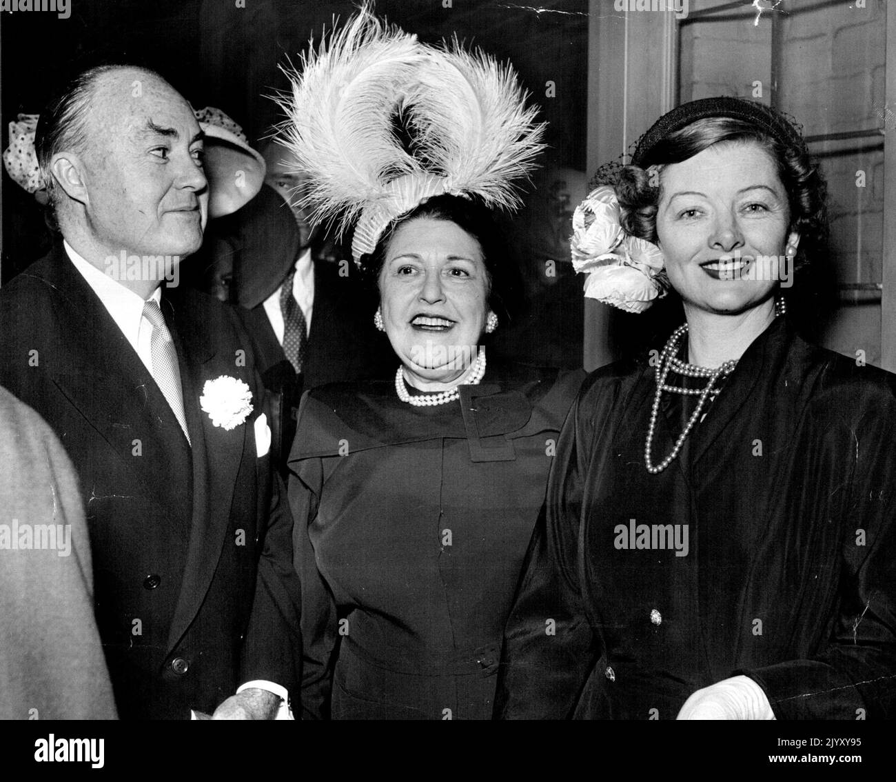 The Markey, once married to the bride's mother, with Myrna Loy, his fourth and present wife. The fabulous creature between them is Louella Parsons, columnist, whose powerful grip on the industry has relaxed somewhat of late - to the stars relief. September 01, 1948. Stock Photo
