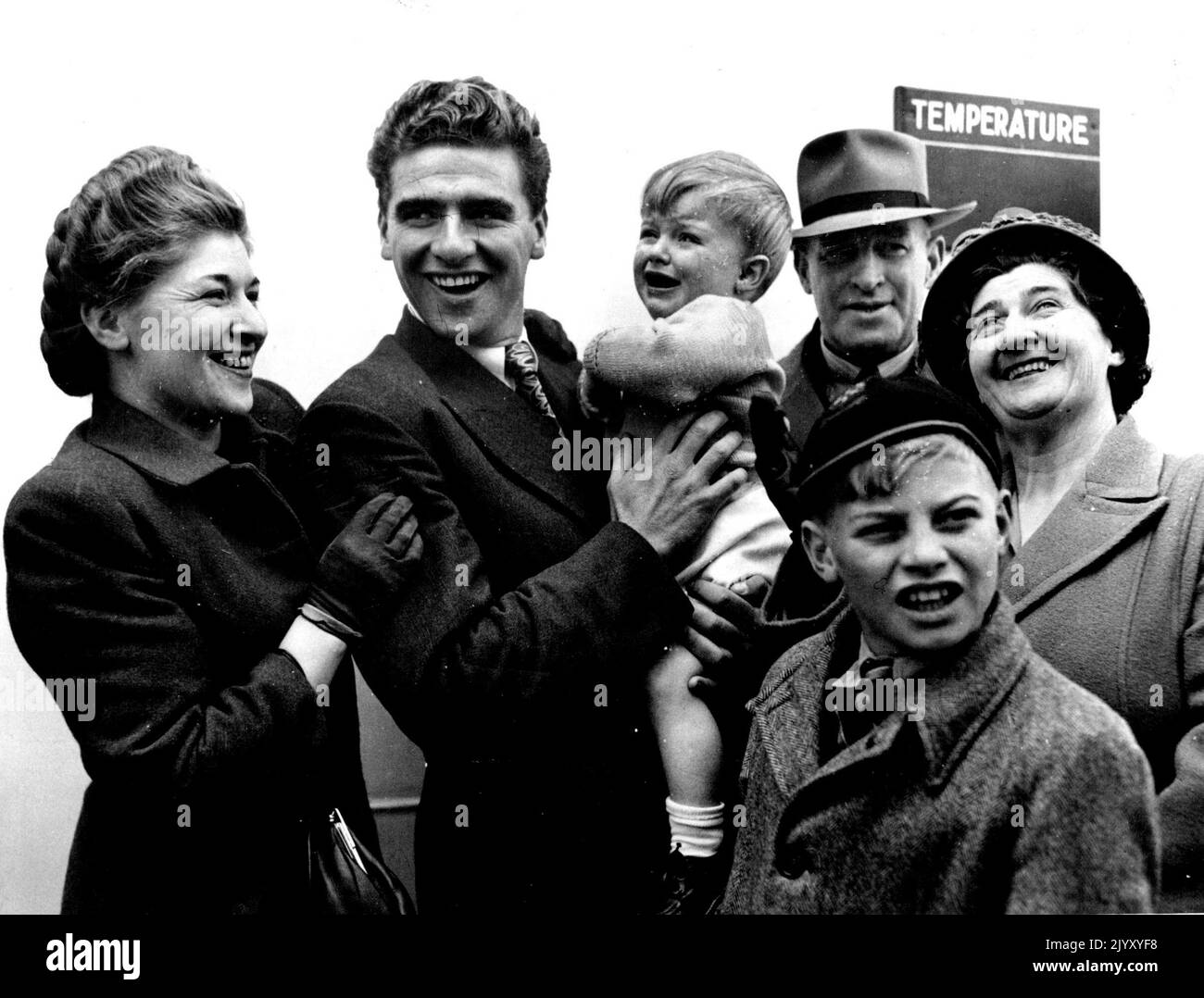World amateur cycling champion, Sid Patterson, greeted in Melbourne by members of his family, on his return on the Himalaya. From left, Mrs. N. Weiss (sister), Sid, holding nephew Michael Weiss, Mr. and Mrs. Patterson (father and mother), and David (brother). November 5, 1949. Stock Photo