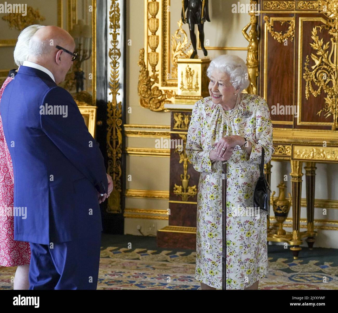 File photo dated 23/3/2022 of Queen Elizabeth II meeting Pamela Harper (hidden) and Dr Peter Harper from British craftwork company, Halcyon Days, as she uses a stick while viewing a display of artefacts to commemorate the company's 70th anniversary in the White Drawing Room at Windsor Castle, Berkshire. The Queen was in robust health for most of her life and seldom took time off during her lengthy reign and illnesses were few and far between over the years. Issue date: Thursday September 8, 2022. Stock Photo