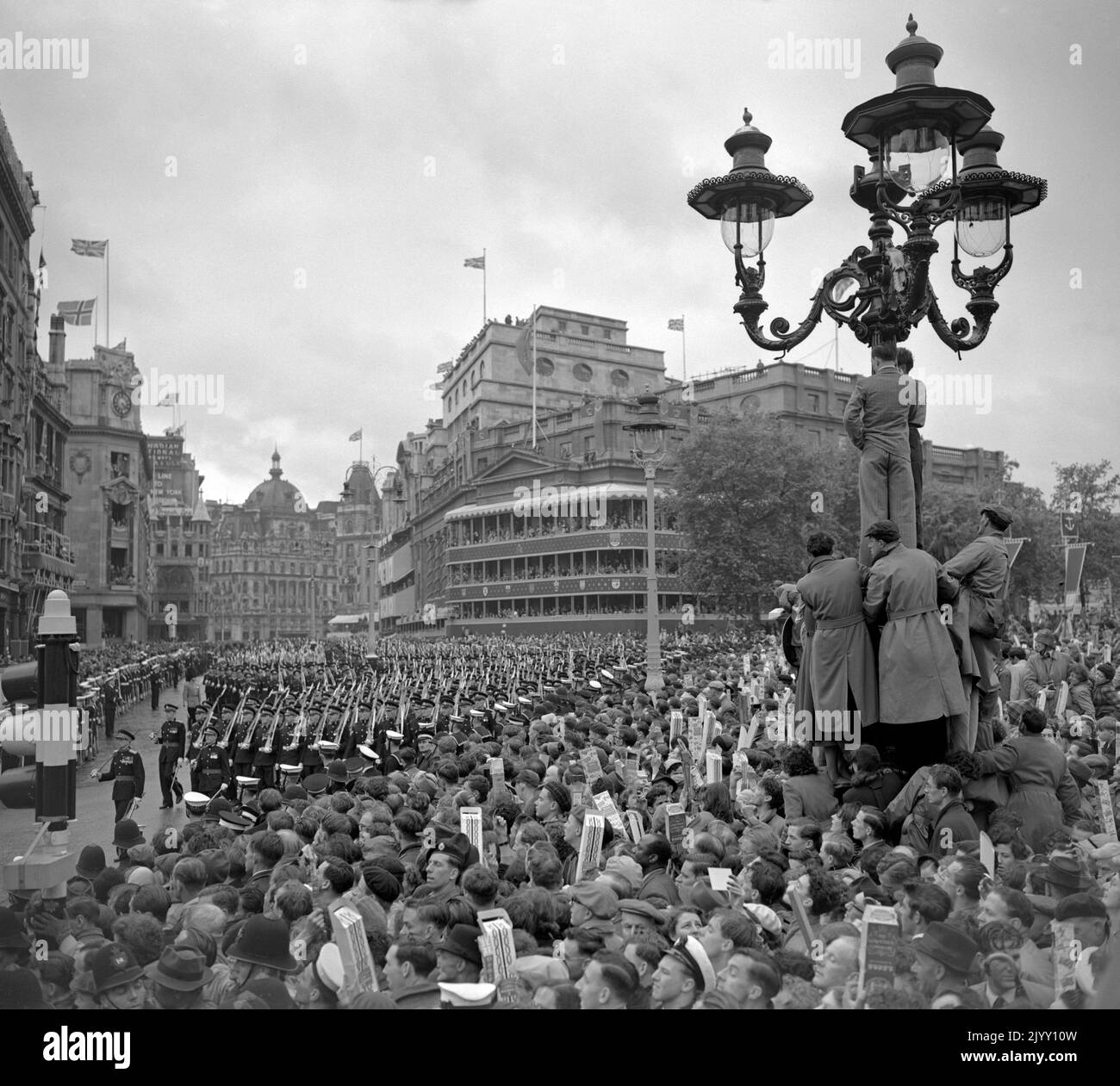 File photo dated 2/6/1953 of crowds in Trafalgar Square in the rain watch as troops march past on the return from Westminster Abbey after the Queen's coronation. The Queen's coronation, rich in religious significance, was a morale boost for a nation starved of pageantry by the war, and for a day street parties banished the hardship of rationing and shortages and even atrocious, unseasonal weather did not dampen the enthusiasm. Issue date: Thursday September 8, 2022. Stock Photo