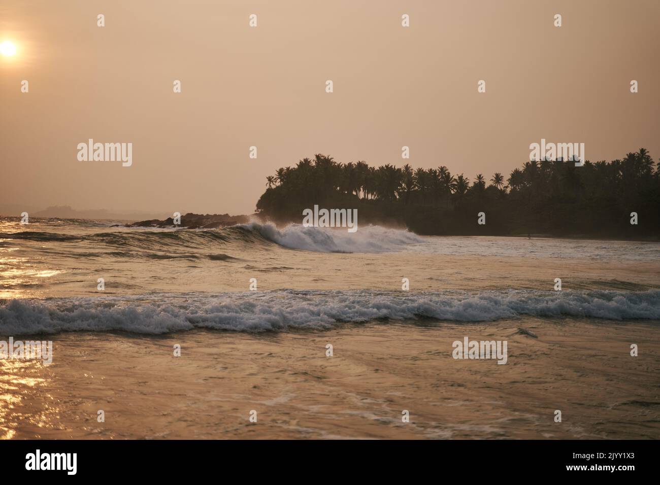 Sunset on the ocean with big waves in Sri Lanka Stock Photo