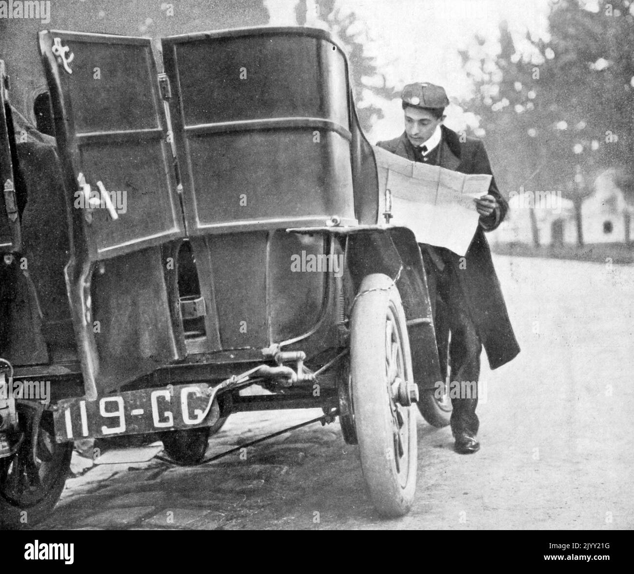 Vintage French photograph of a car rally driver looking at a route map during a race in 1905 Stock Photo