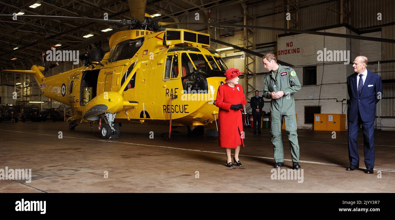 File photo dated 1/4/2011 of Prince William showing Queen Elizabeth II and the Duke of Edinburgh the Sea King Helicopter he flies during his training as a Search and Rescue pilot during a visit to RAF Valley in Anglesey. Issue date: Thursday September 8, 2022. Stock Photo