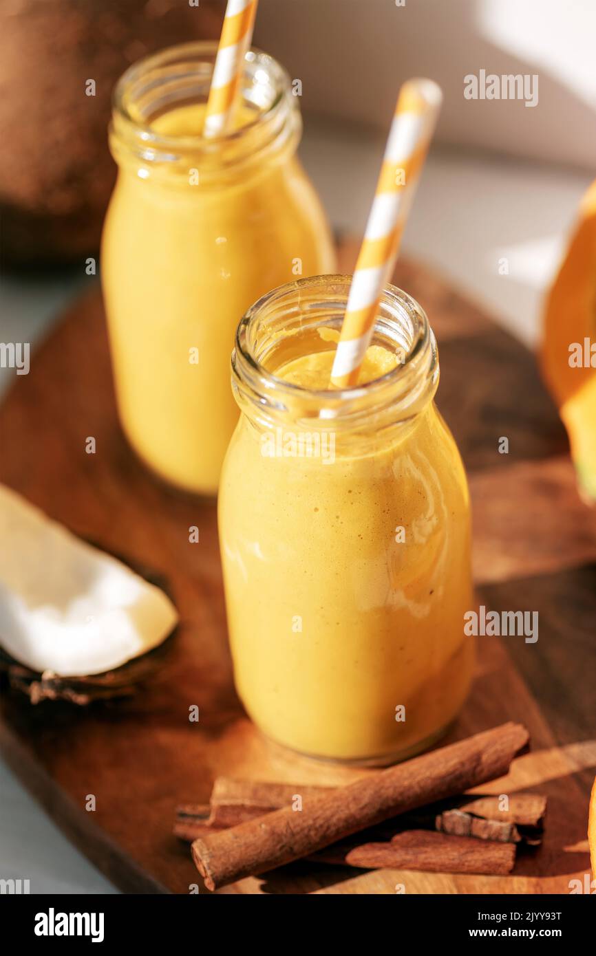 Pumpkin and coconut smoothie with cinnamon in bottles with straw. Healthy raw vegan food. Closeup. Stock Photo