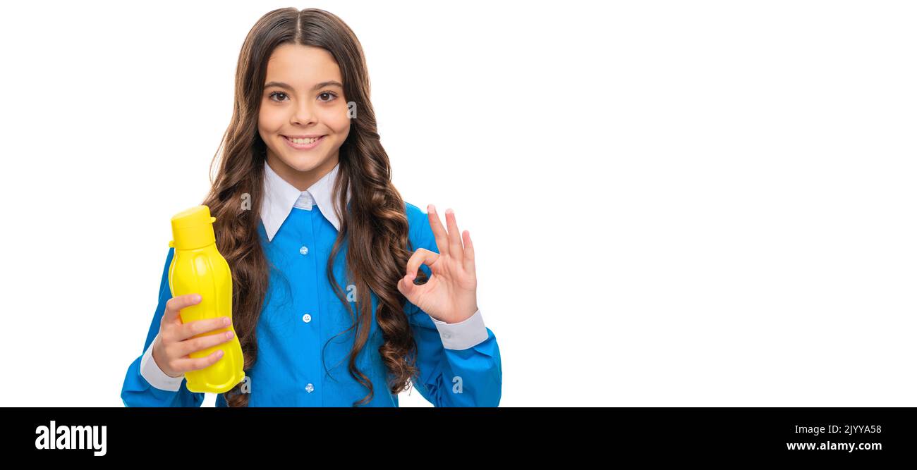 Happy girl show OK sign holding yellow plastic drinking water bottle
