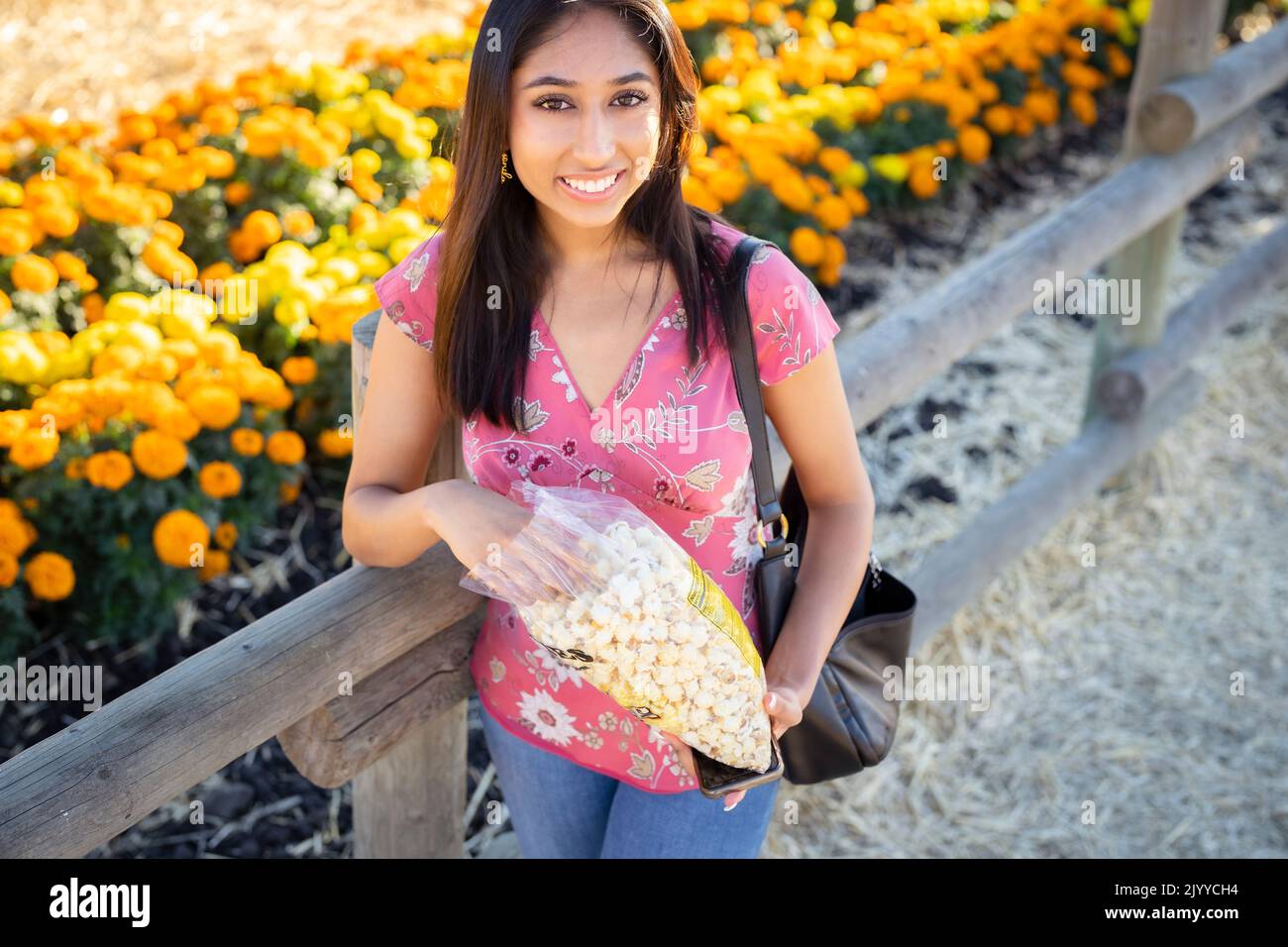 Fall Celebration Portrait of Young Asian Woman Standing in Front of a Field of Orange and Yellow Marigolds | Eating Kettle Co Stock Photo