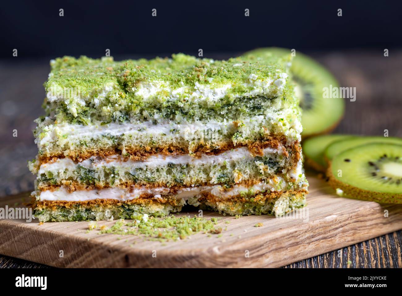 a piece of green cake with creamy filling, fresh and sweet green cake with sliced green kiwi fruit Stock Photo