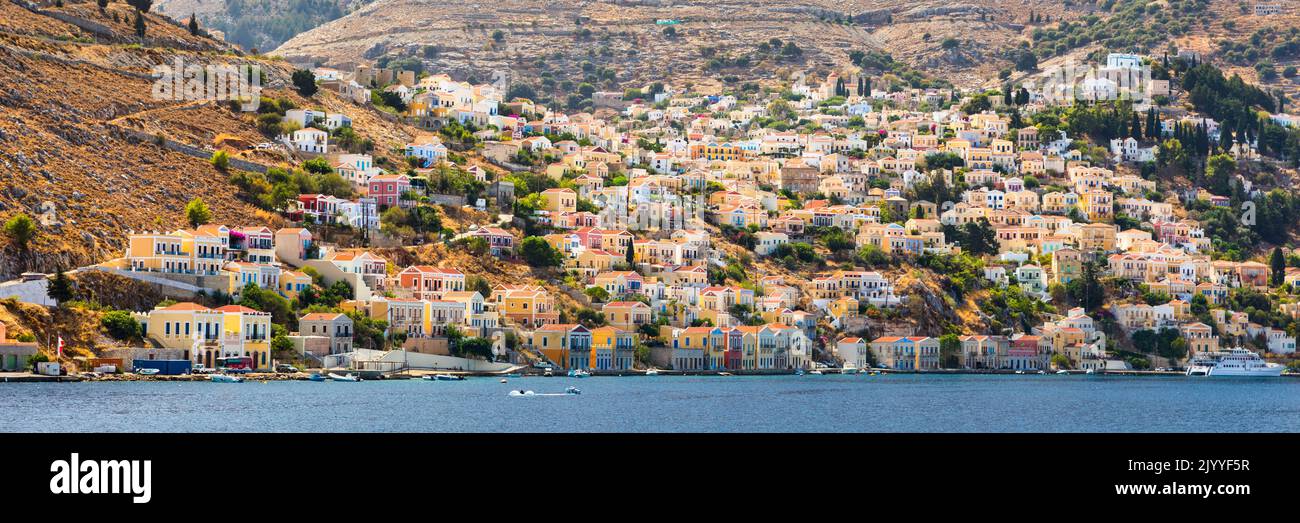 View of the beautiful greek island of Symi (Simi) with colourful houses and small boats. Greece, Symi island, view of the town of Symi (near Rhodes), Stock Photo