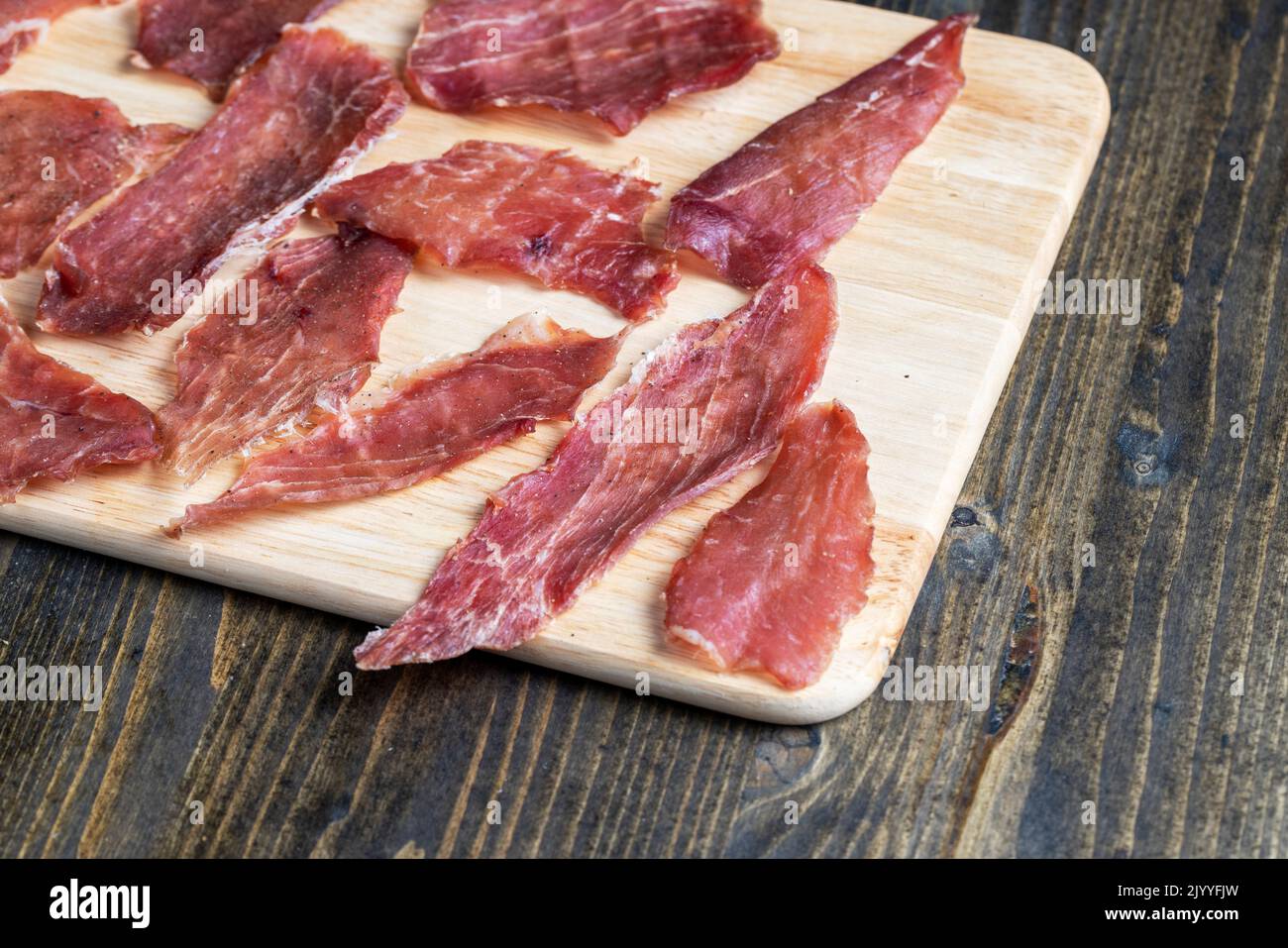 thin pieces of dried meat with spices , pork meat food during cooking in the kitchen Stock Photo