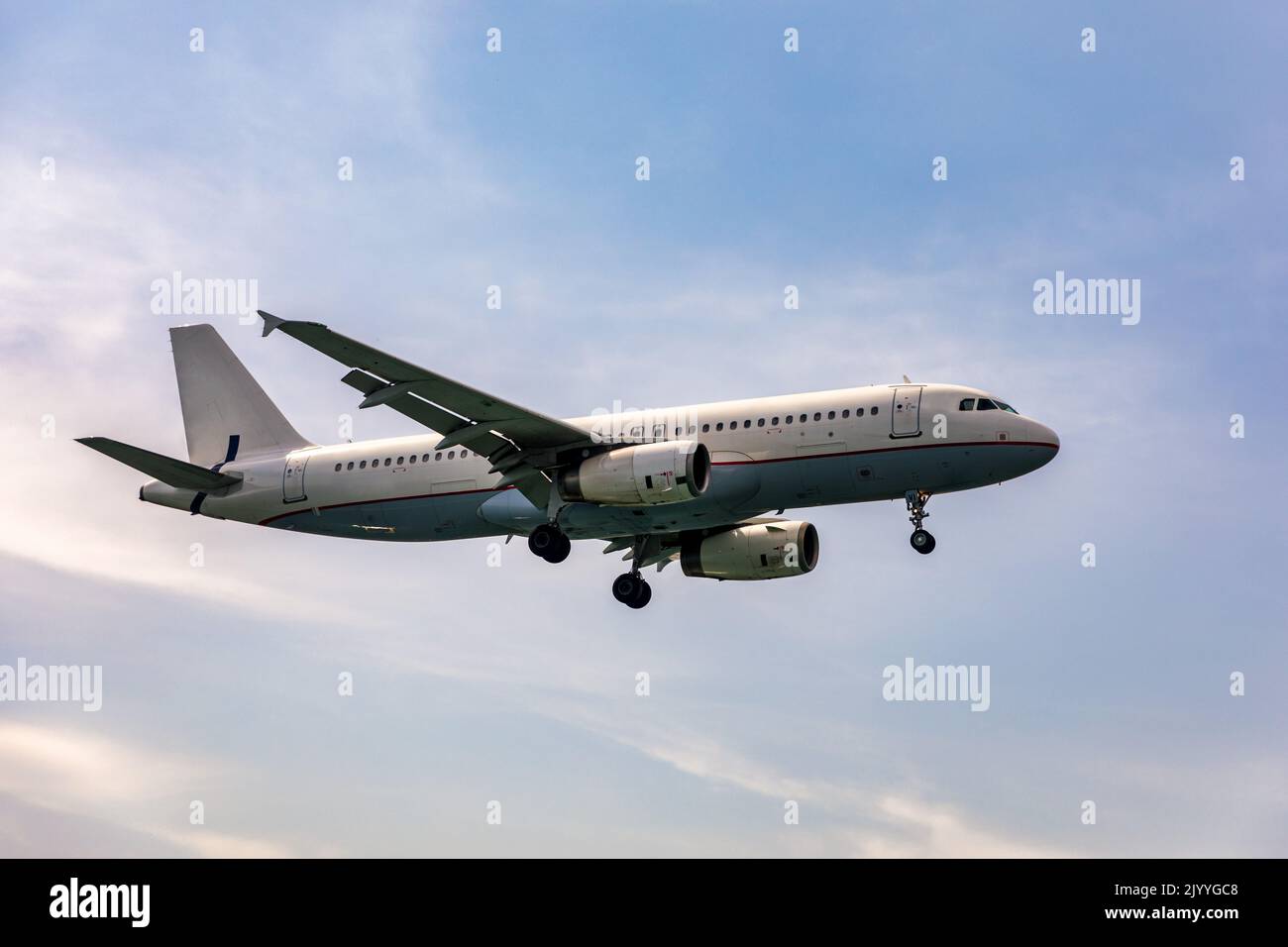 Landing airplane. Landscape with passenger airplane is flying in the blue sky with clouds. Passenger airliner. Business trip. Commercial aircraft. Pas Stock Photo